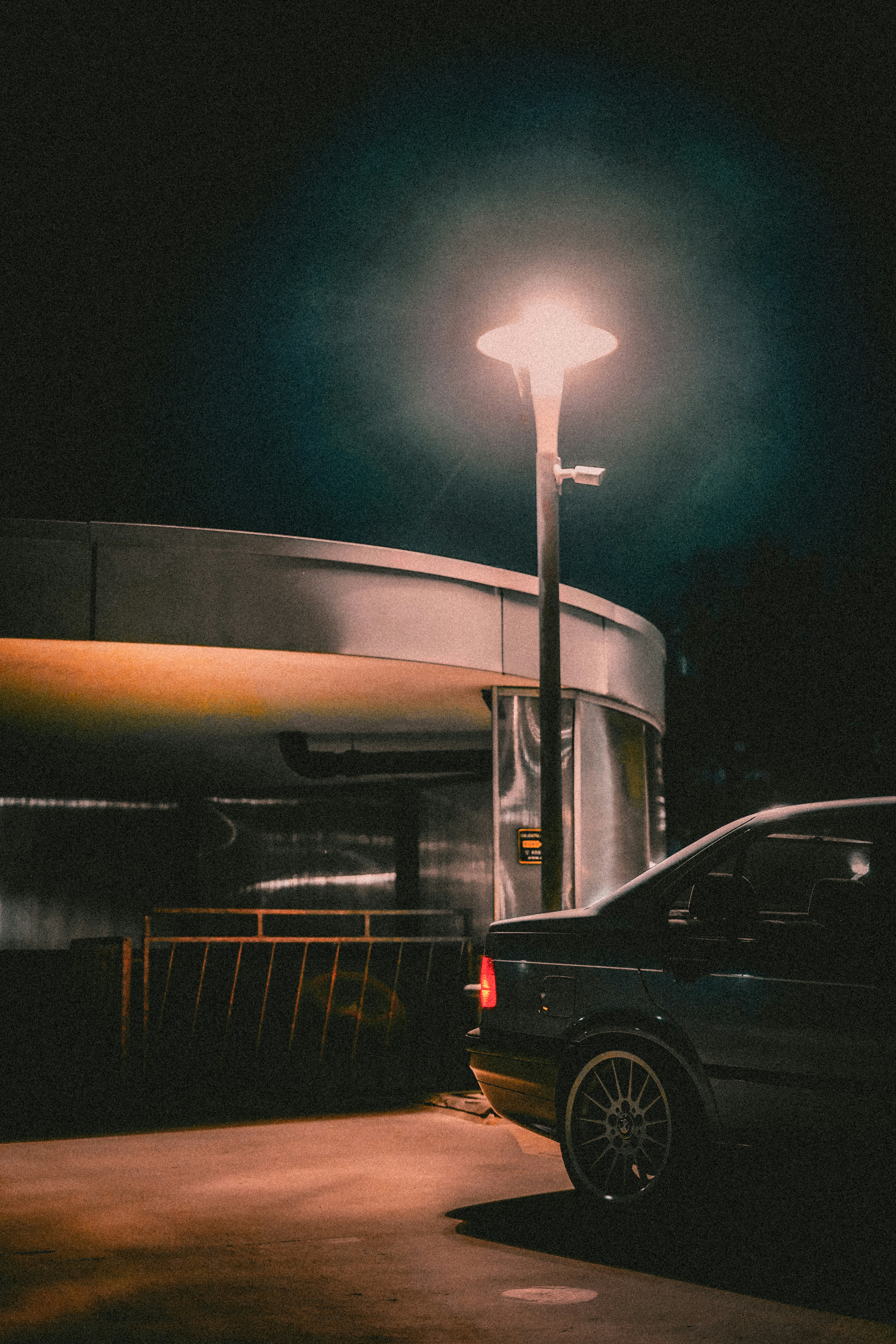 Car parked under a streetlamp at night