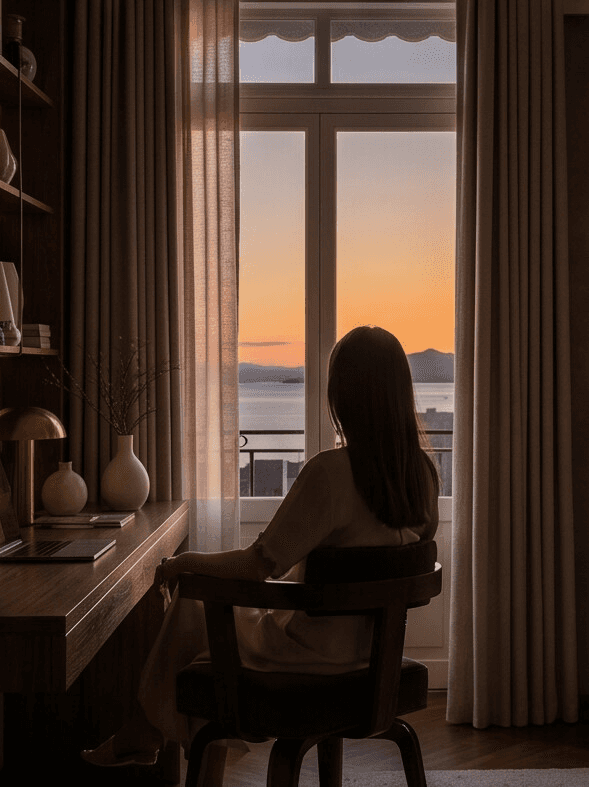 Silhouette contemplant le coucher de soleil sur le lac Léman depuis une chambre d'hôtel design