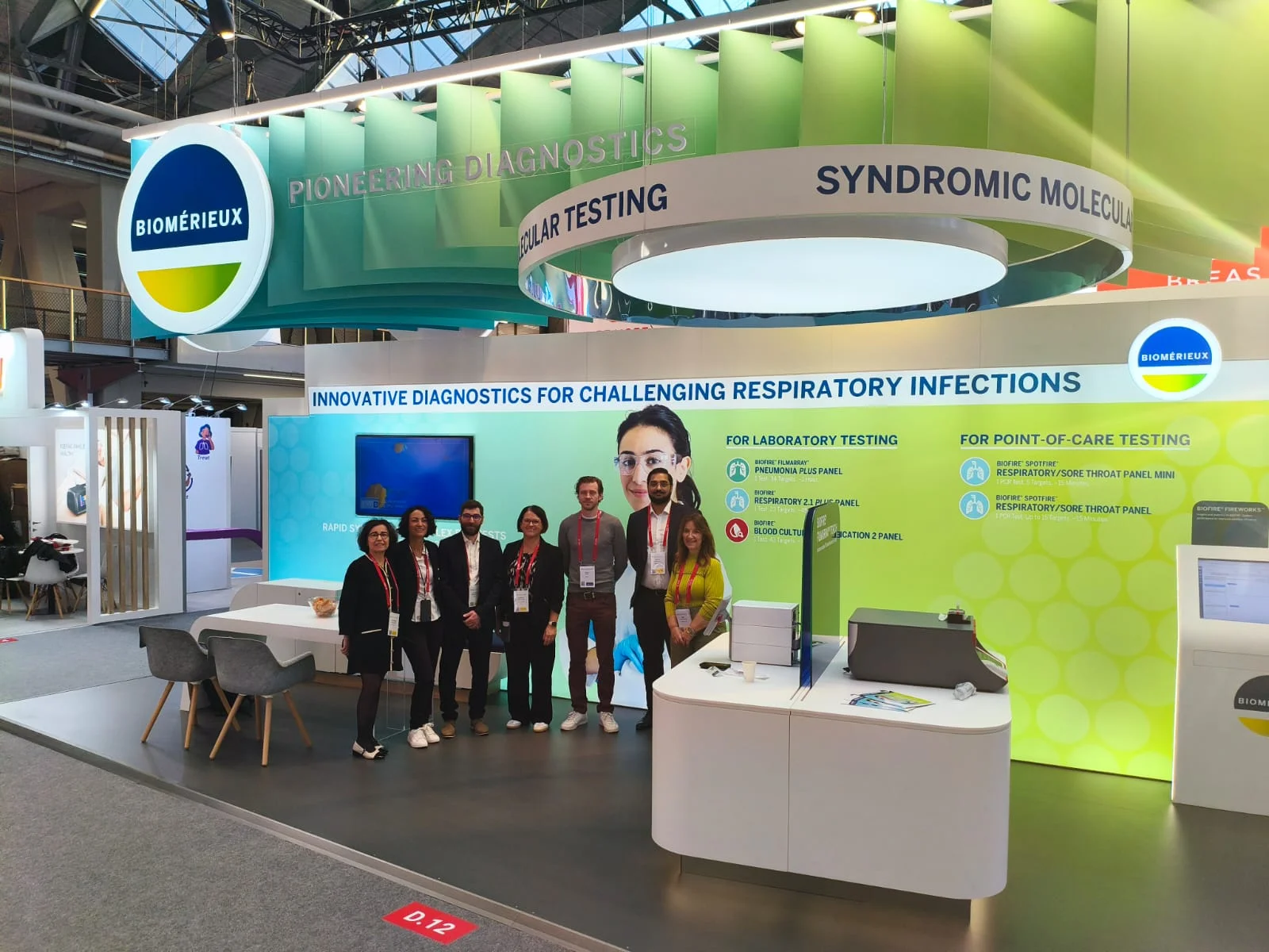 équipe Biomérieux devant le stand ERS 2025 avec grande fresque verte dédiée aux infections respiratoires