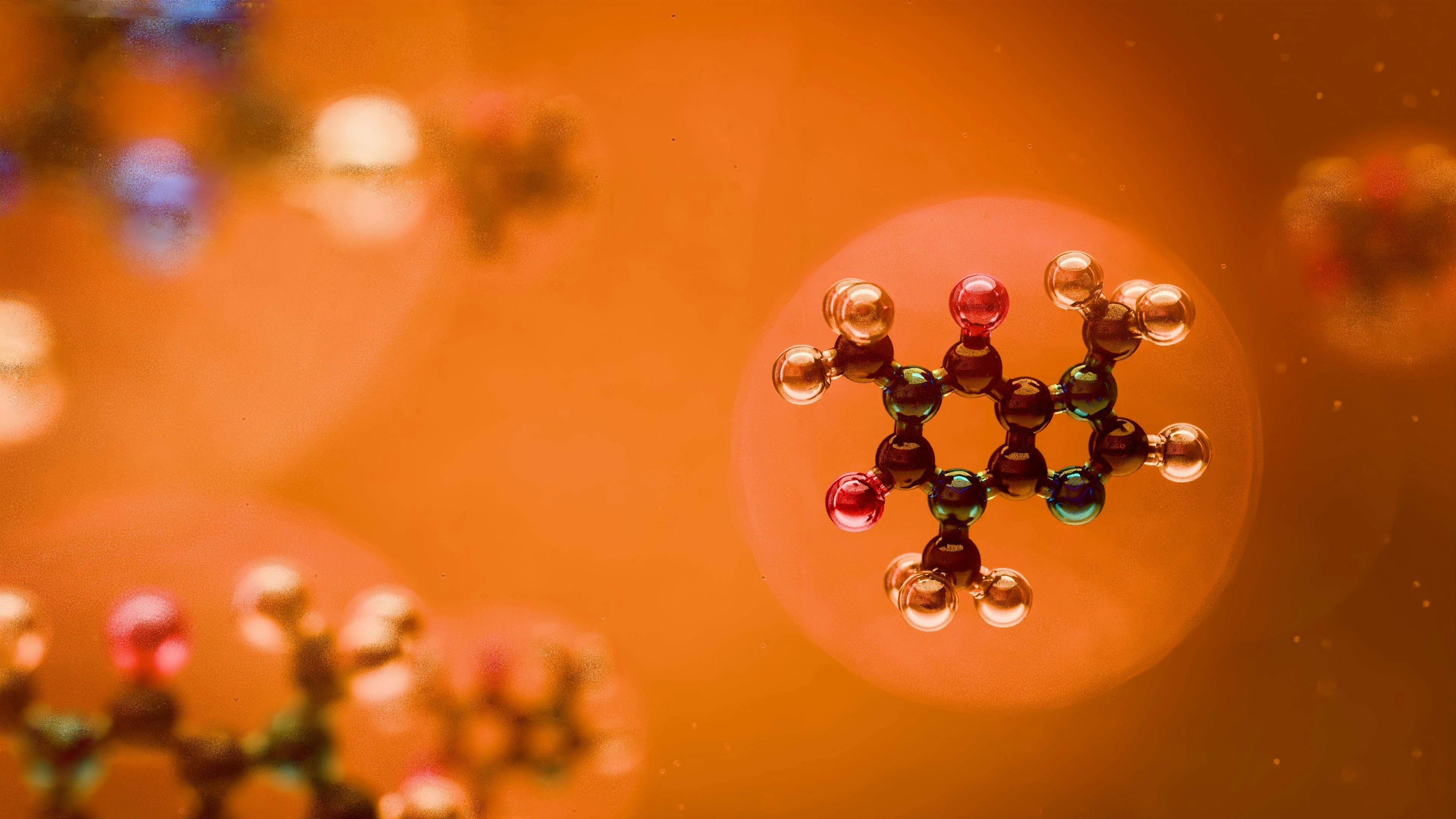 Molecular structures are seen against an orange backdrop.