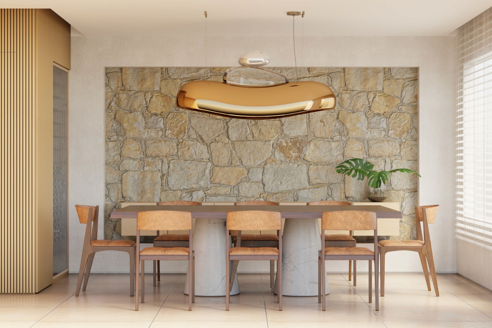 Contemporary dining room with a sculptural bronze and glass pendant light above a wooden dining table, set against a natural stone wall in a warm modern interior.