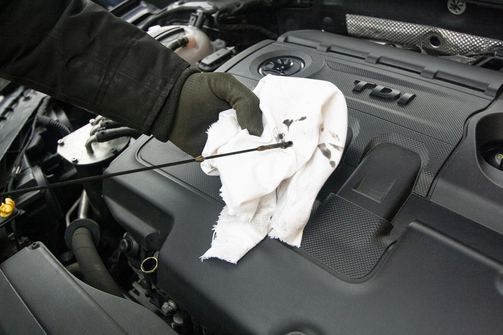 Man using dipstick to check oil levels