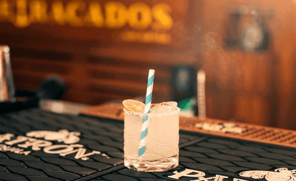 Margarita con popote a rayas sobre la barra de Atracados.