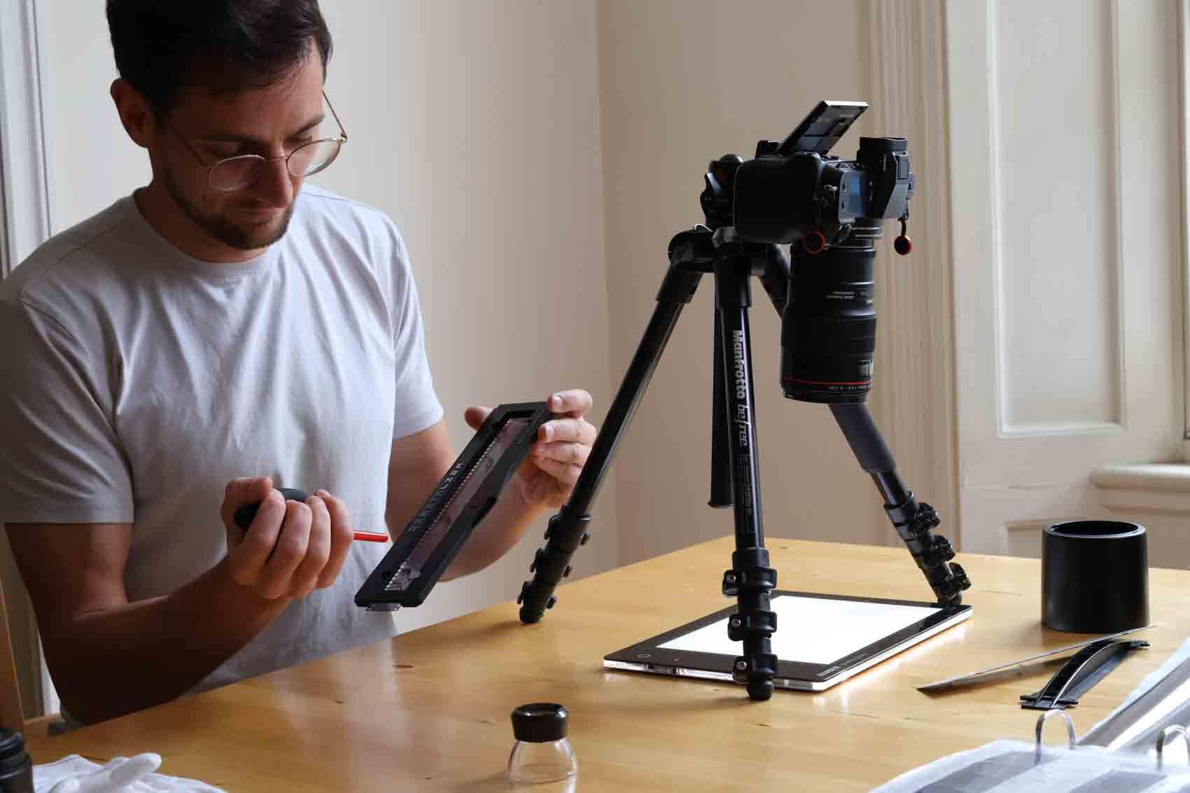Photographer scanning film with a DSLR on a light box