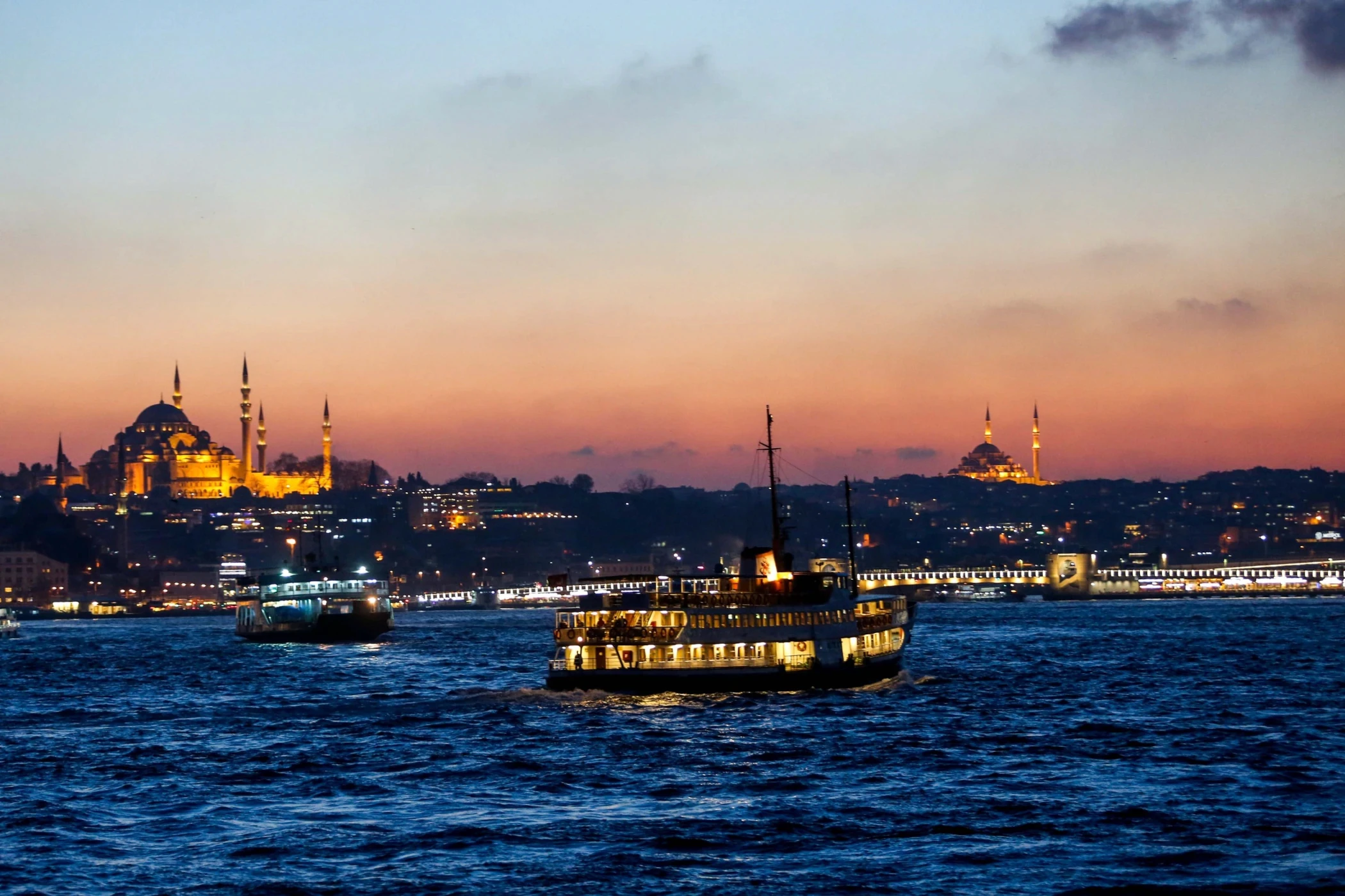A beautifully set dining table with white tablecloth, cutlery, and fresh greenery in a cozy, well-lit space.