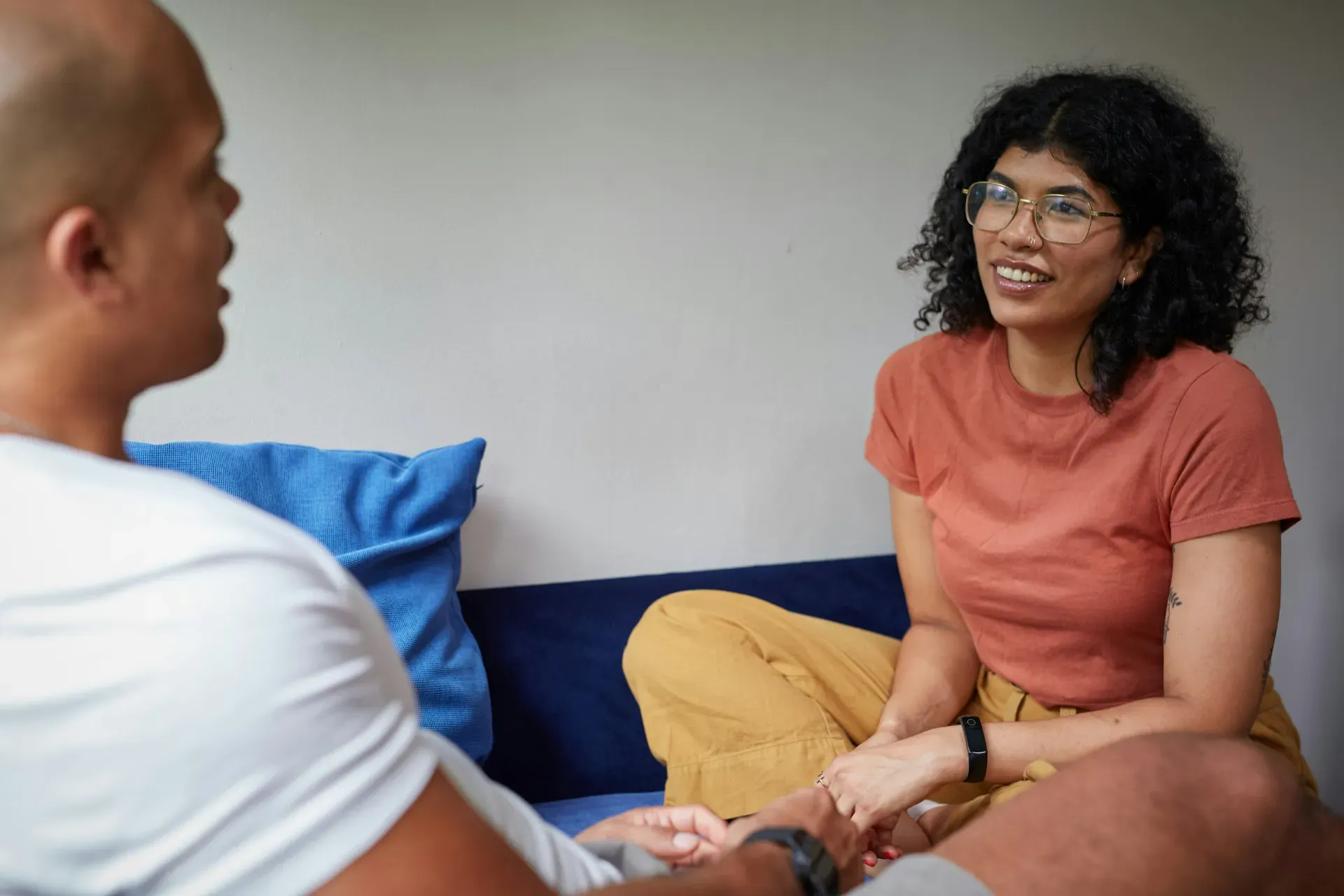 A woman talking to antoher person while sitting on a couch