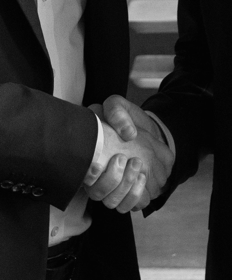 Two professionals shaking hands, symbolising amicable debt recovery and soft collections services.