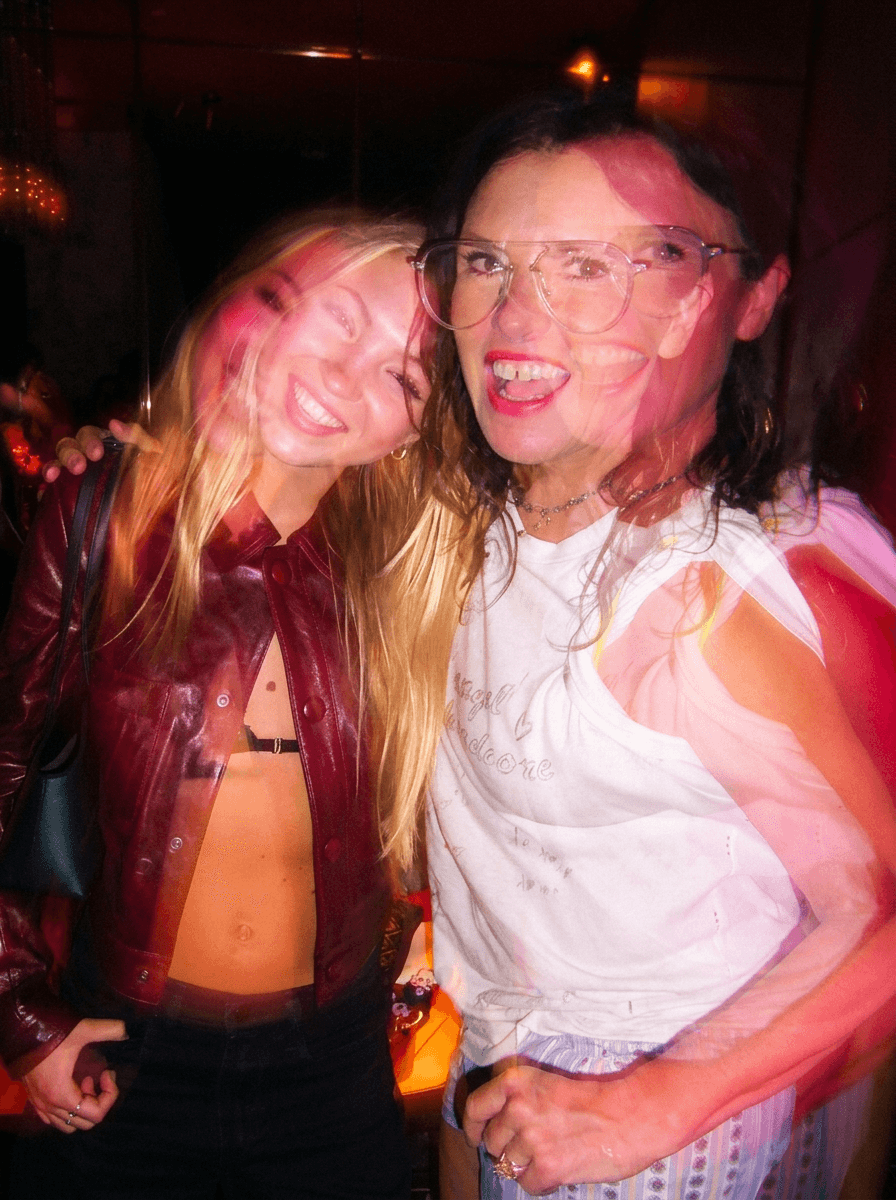 Dancer in black outfit with arms raised, arching backwards