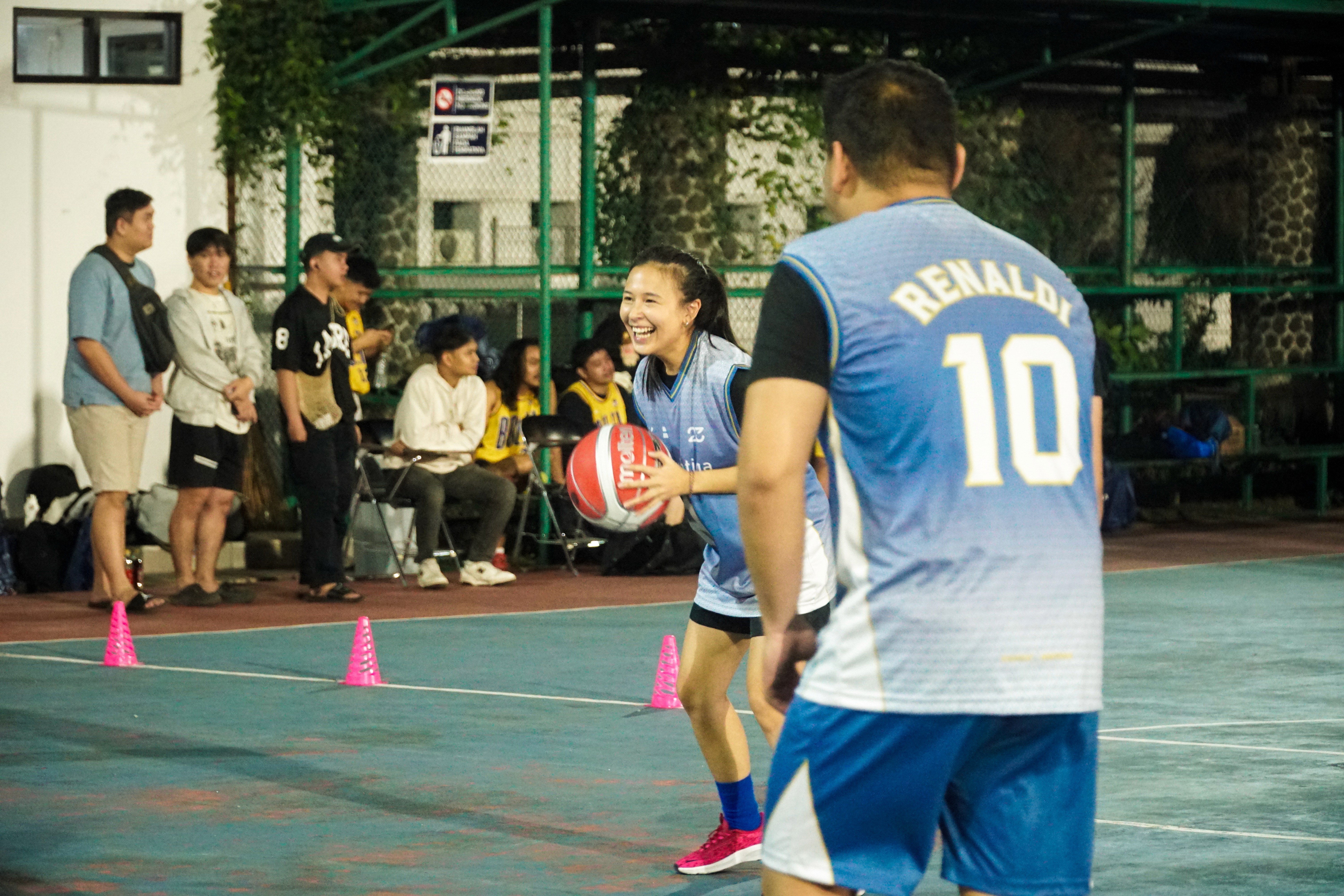 person in gray hoodie holding red and white box