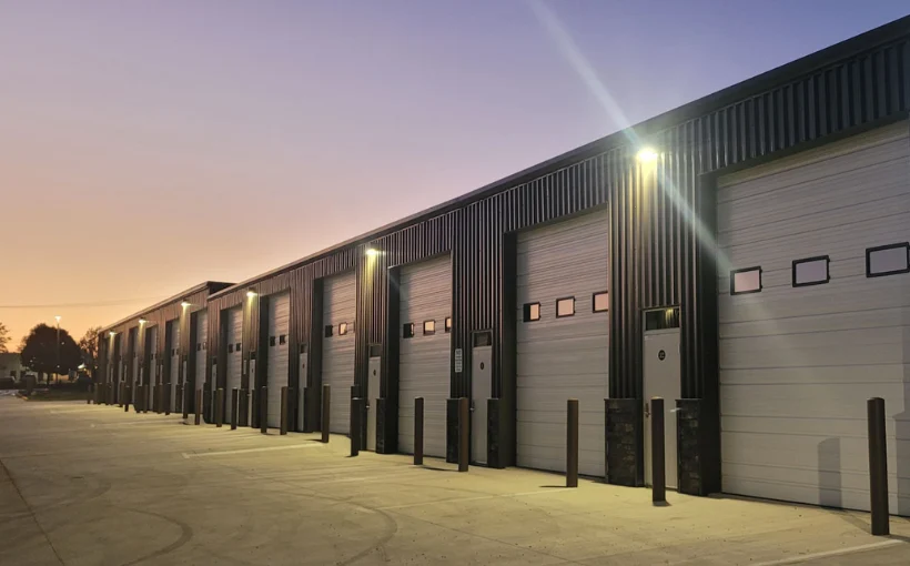 Tall modern skyscraper with vertical lines, viewed against a clear blue sky.