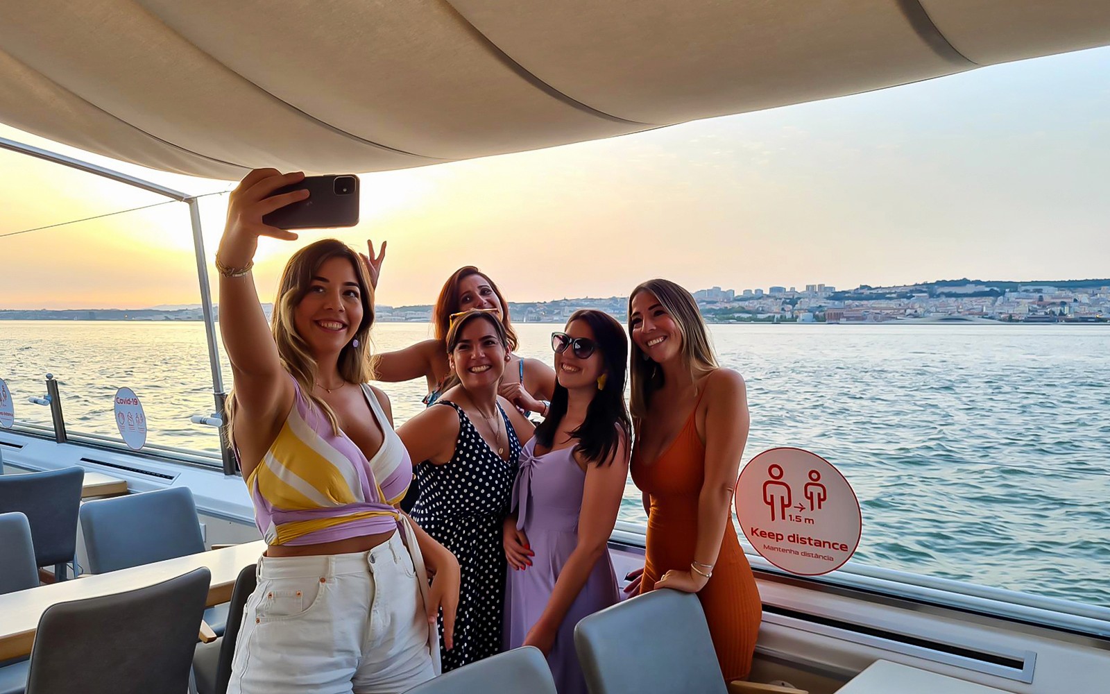 Grupa ciesząca się rejsem o zachodzie słońca po rzece Tag w Lizbonie.