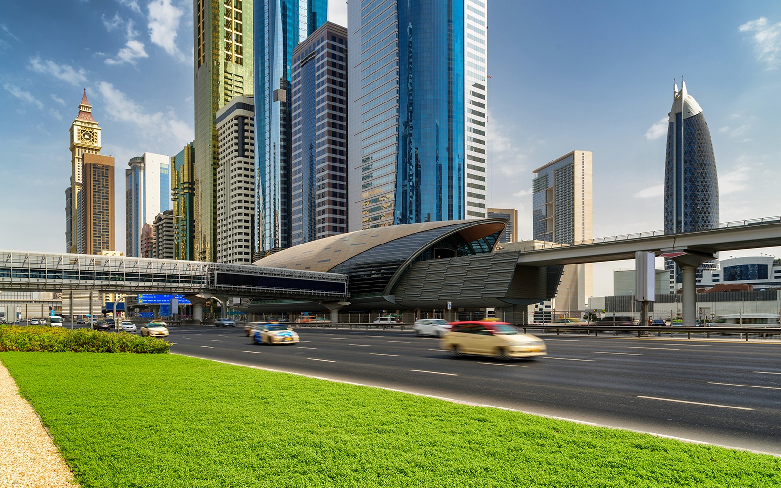 दुबई के आधुनिक गगनचुंबी इमारतों और राजमार्ग के साथ शहर का दृश्य, जिसमें निजी हवाई अड्डा स्थानांतरण को उजागर किया गया है।