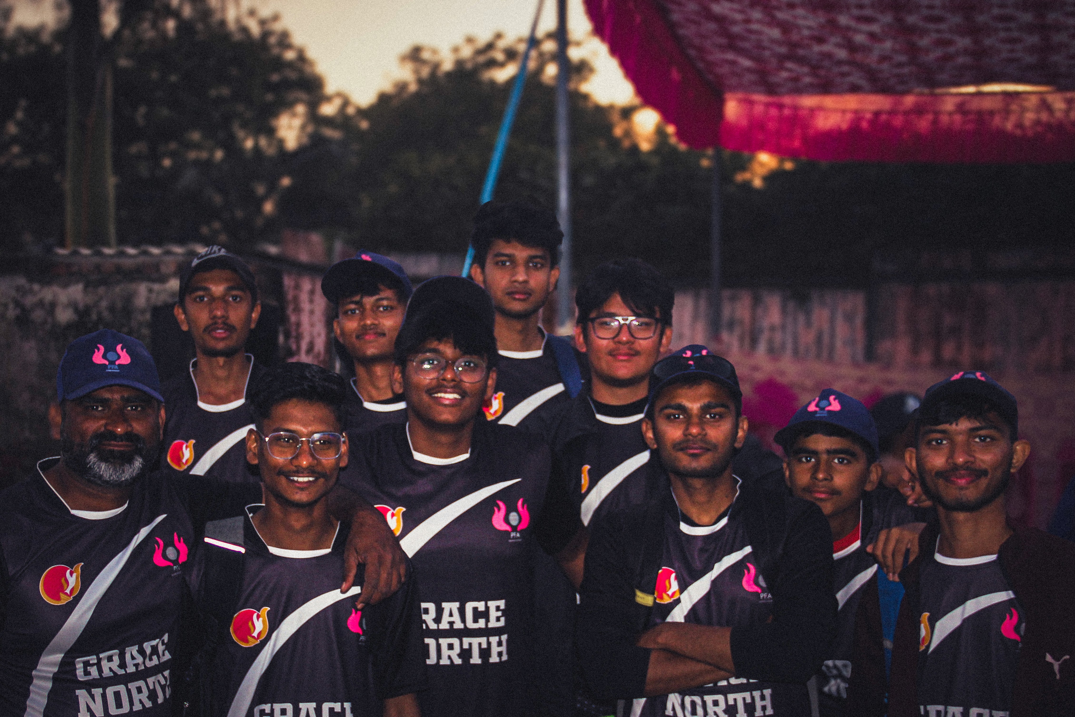 Candid outdoor portrait photography of friends in sports jerseys, captured by Samuel Singh Bhakuni – natural smiles and vibrant energy.