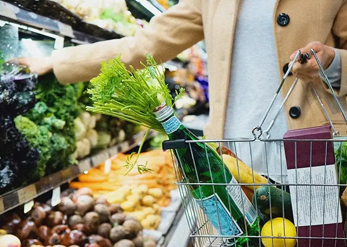 Persona comprando verduras frescas en un supermercado