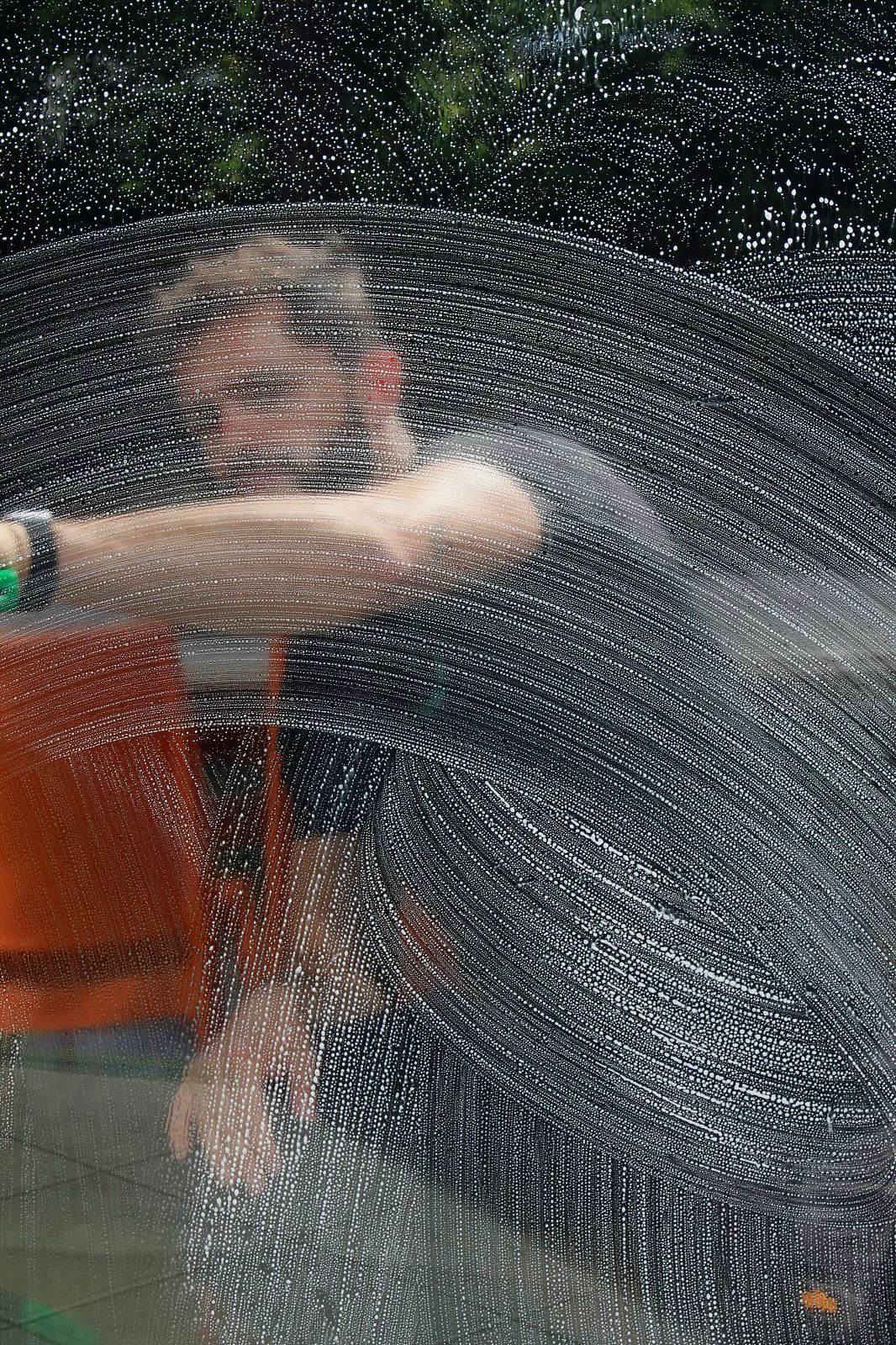 Technicien Propre et Net en train de nettoyer une baie vitrée avec matériel professionnel