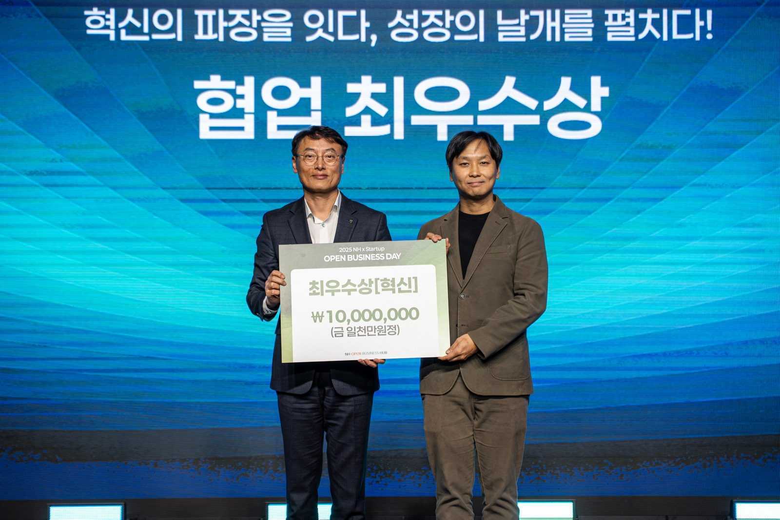2025 NH오픈비즈니스데이에서 강지홍 로민 대표(오른쪽)가 최우수혁신상을 받고 최운재 NH농협은행 부행장과 사진촬영을 하고 있다.