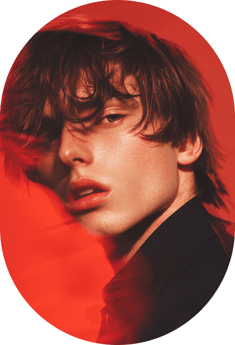 Young man with tousled hair lit in deep red tones