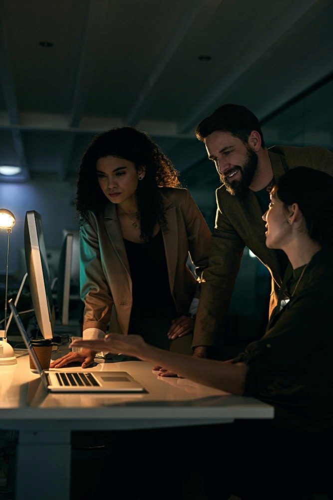 three people sitting in front of table laughing together
