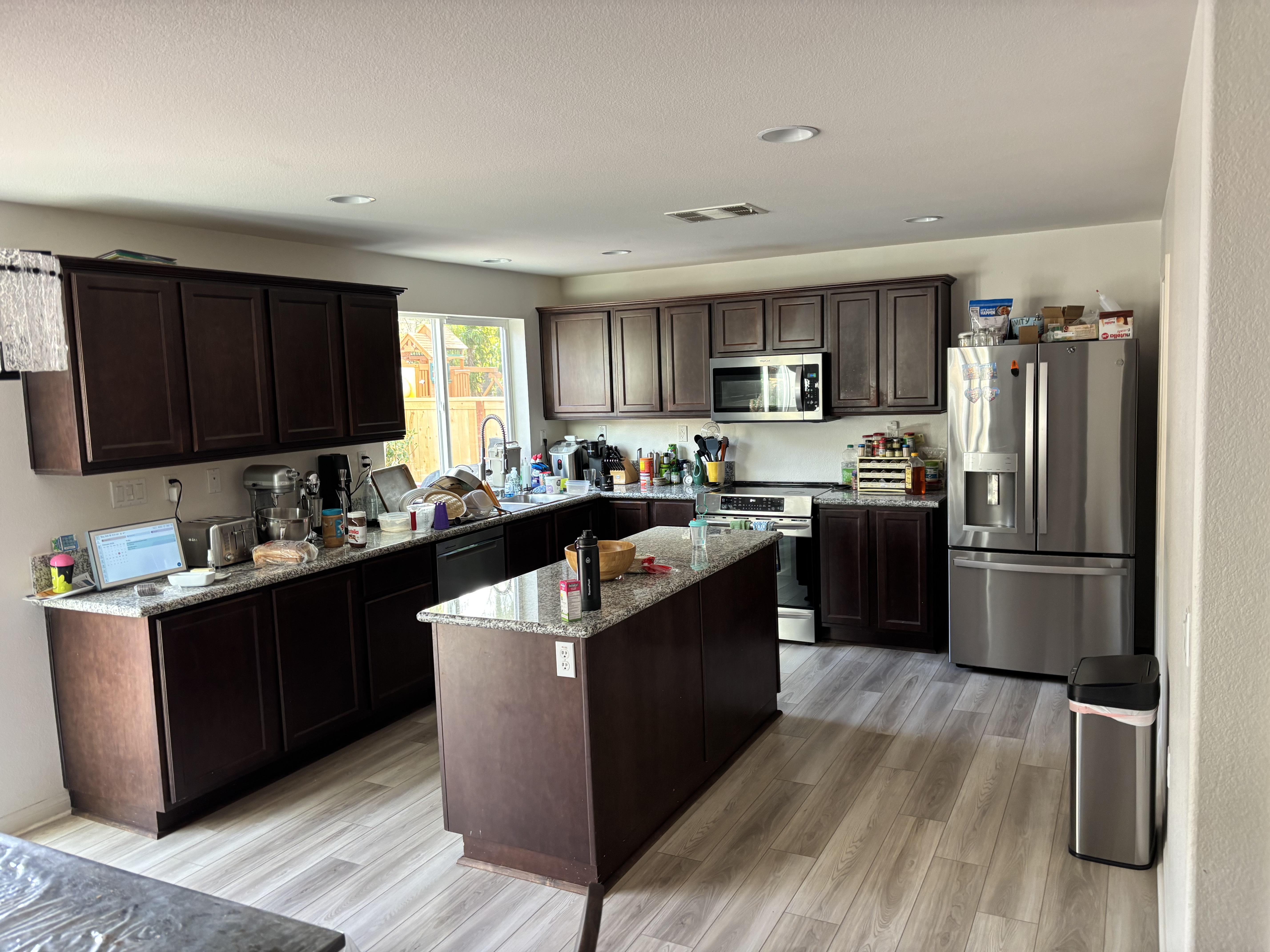The original kitchen — dark espresso cabinets, brown granite, dim lighting