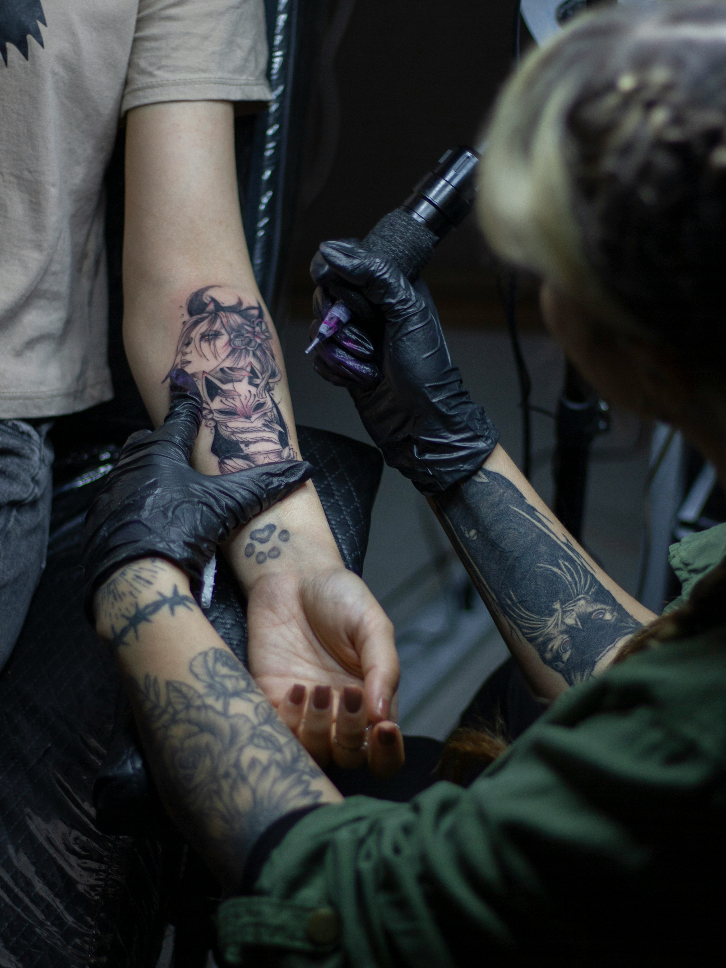 a person getting a tattoo on another person's arm