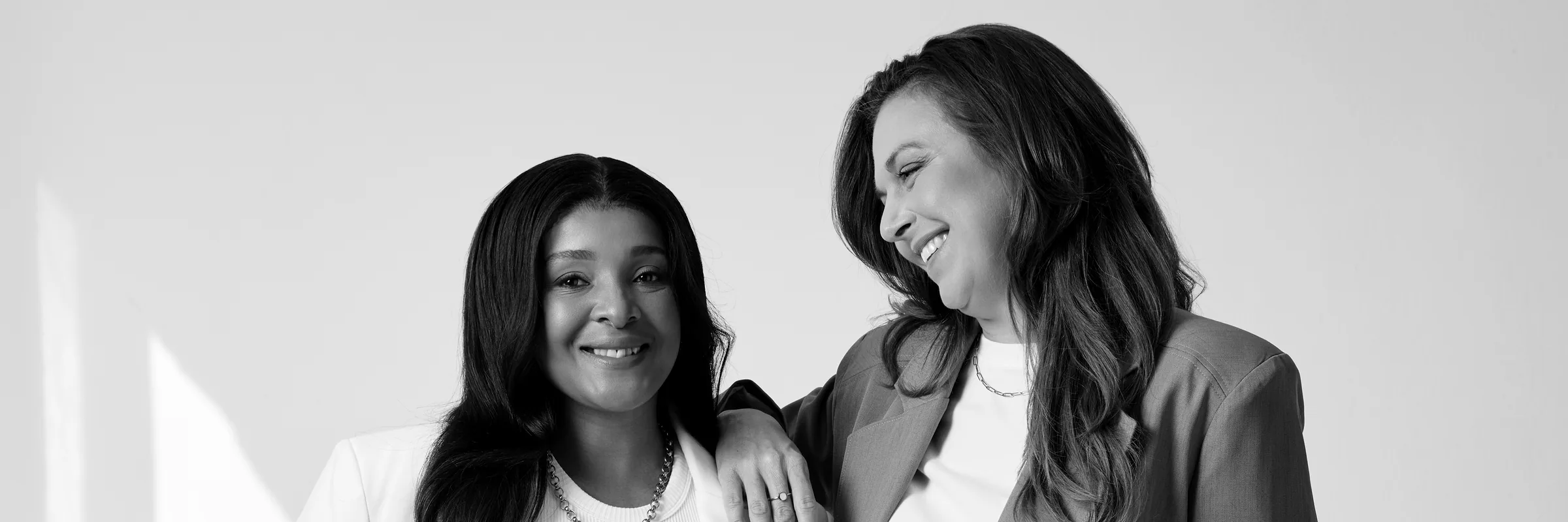 Sēkret founders Roz and Zola standing together in a bright studio, in black and white