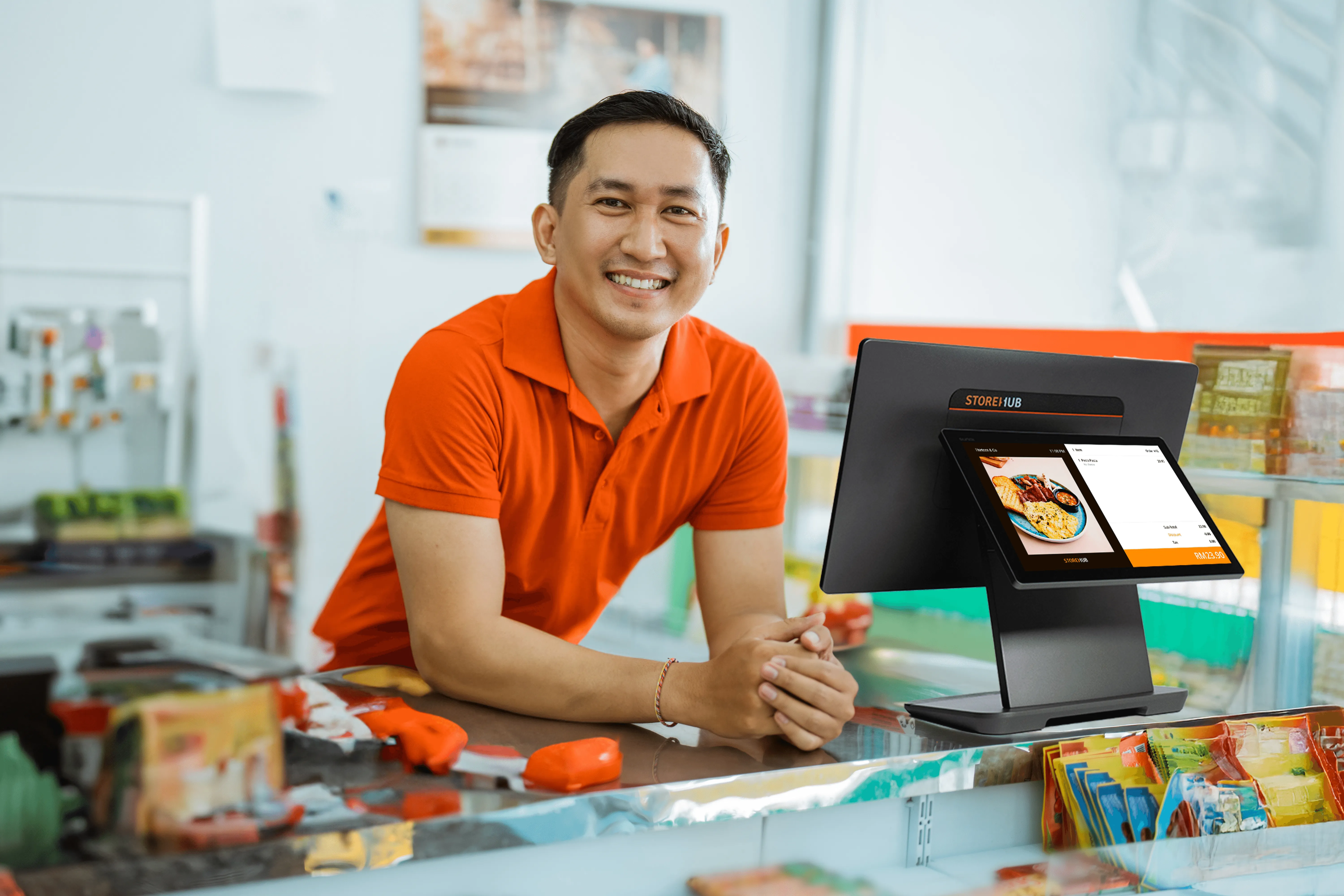 Malaysian convenience store owner using the StoreHub retail POS system for inventory management and checkout transactions.