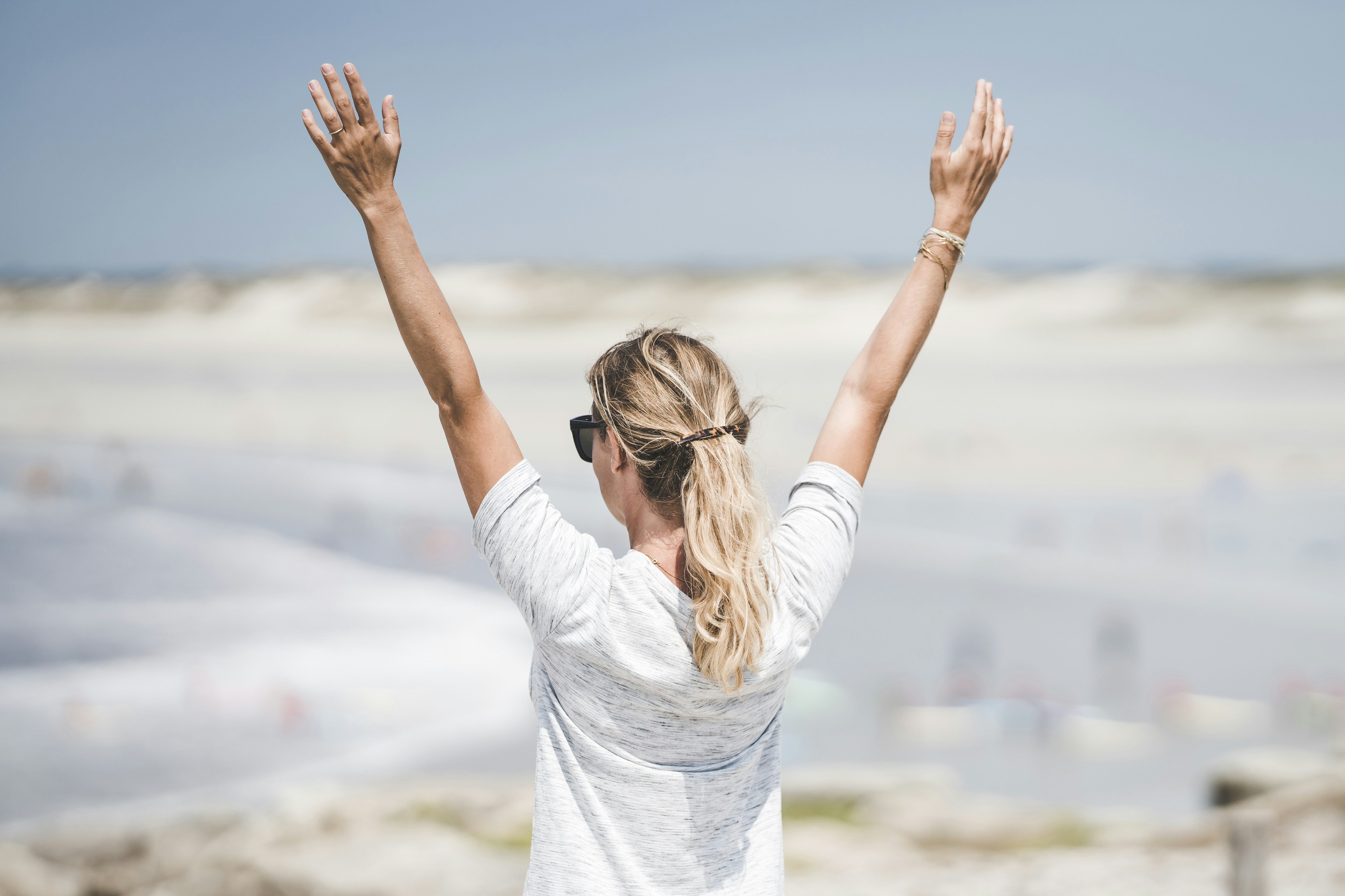 woman happy on the beach - How To Have A Glow Up Overnight