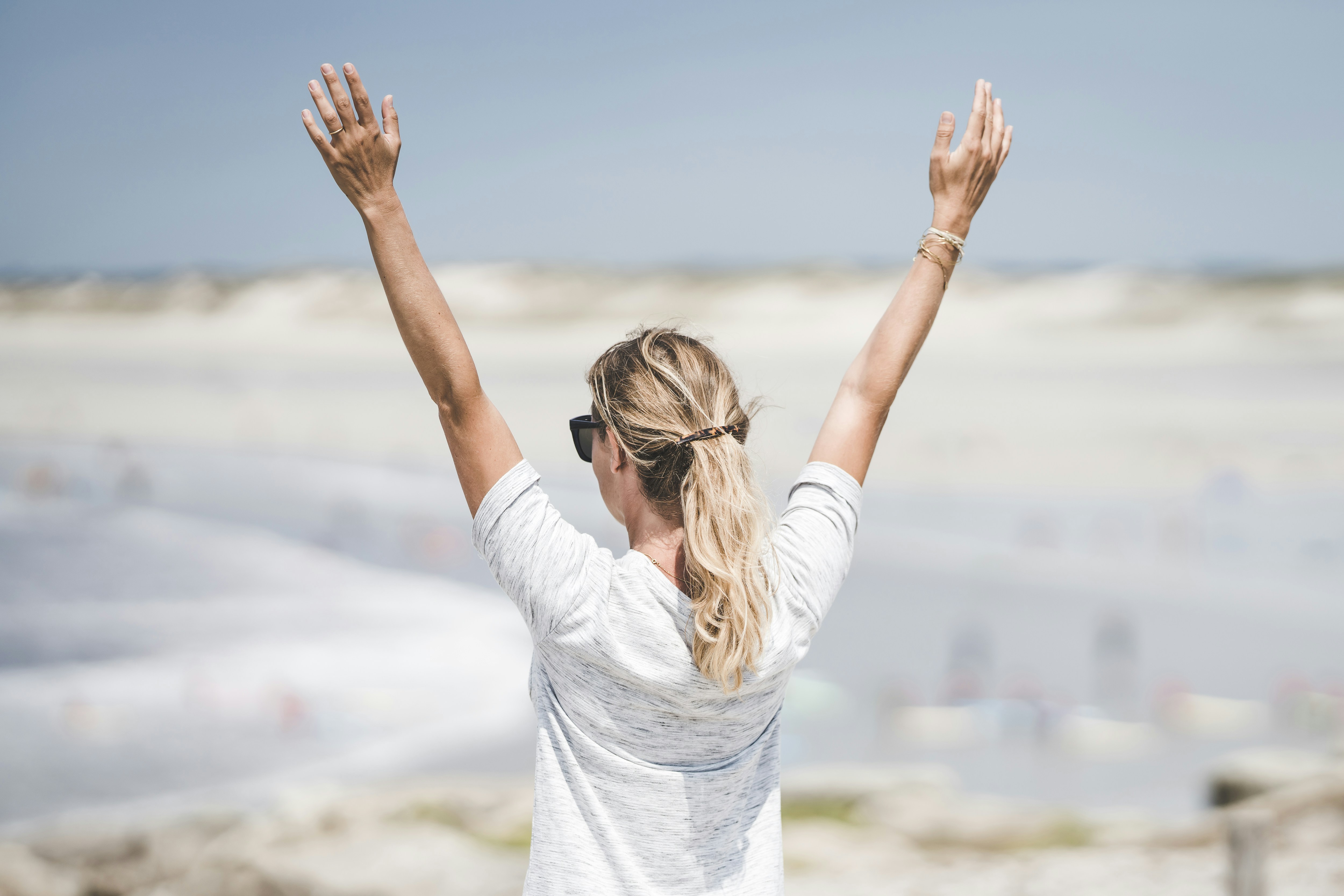 woman in white long sleeve shirt raising her hands