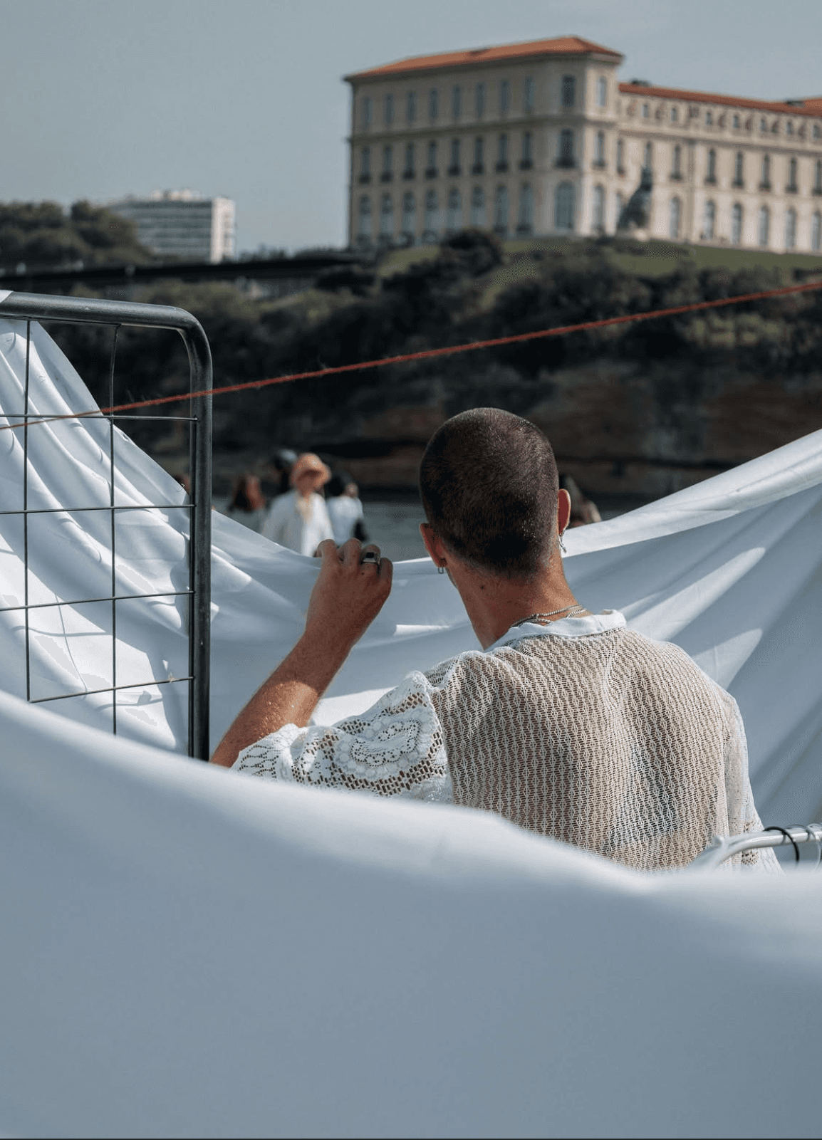 Coulisses du défilé écoresponsable organisé par Studio Paillette et Salé Collections à la Slow Fashion Week 2025 à Marseille, avec vue sur le Palais du Pharo. Une immersion dans les préparatifs, entre dentelle, soleil et esprit collectif.