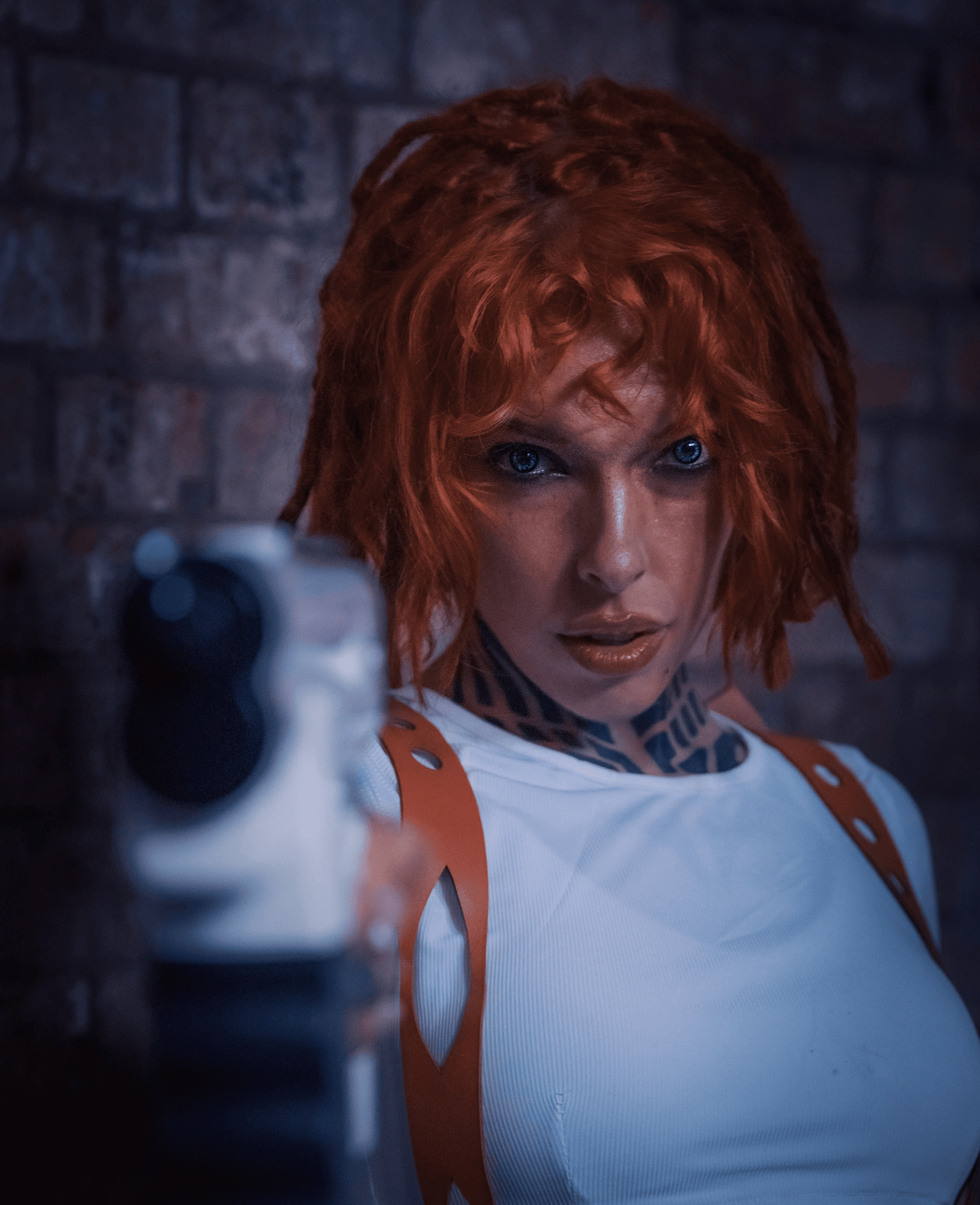 Fifth Element red haired woman with gun pointing at camera