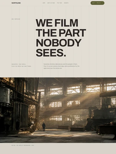 Video production website built with AI showing a Swiss grid hero with an uppercase headline and a full bleed still of a sunlit factory floor with one worker