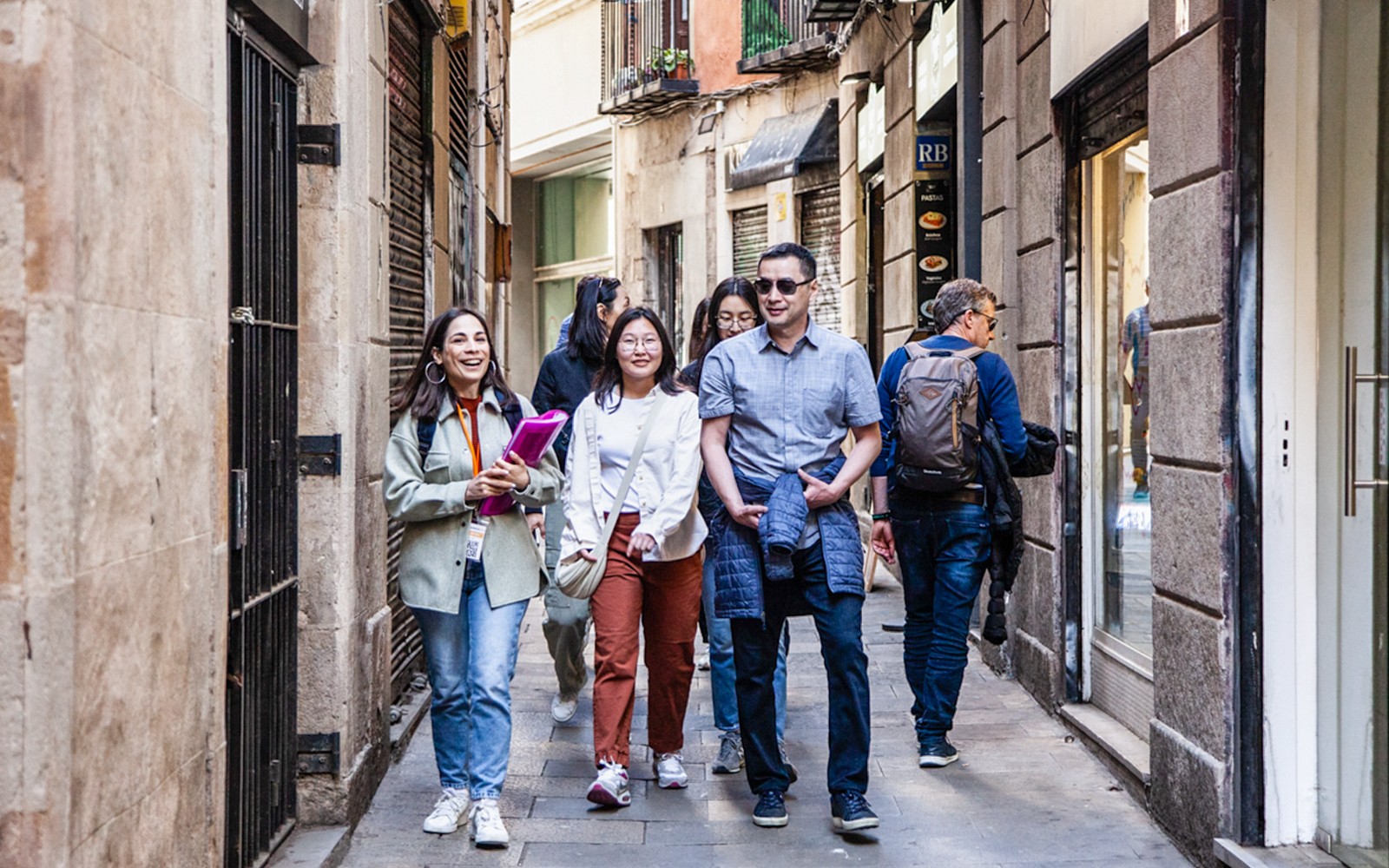 Guests walking with guide through narrow European street.