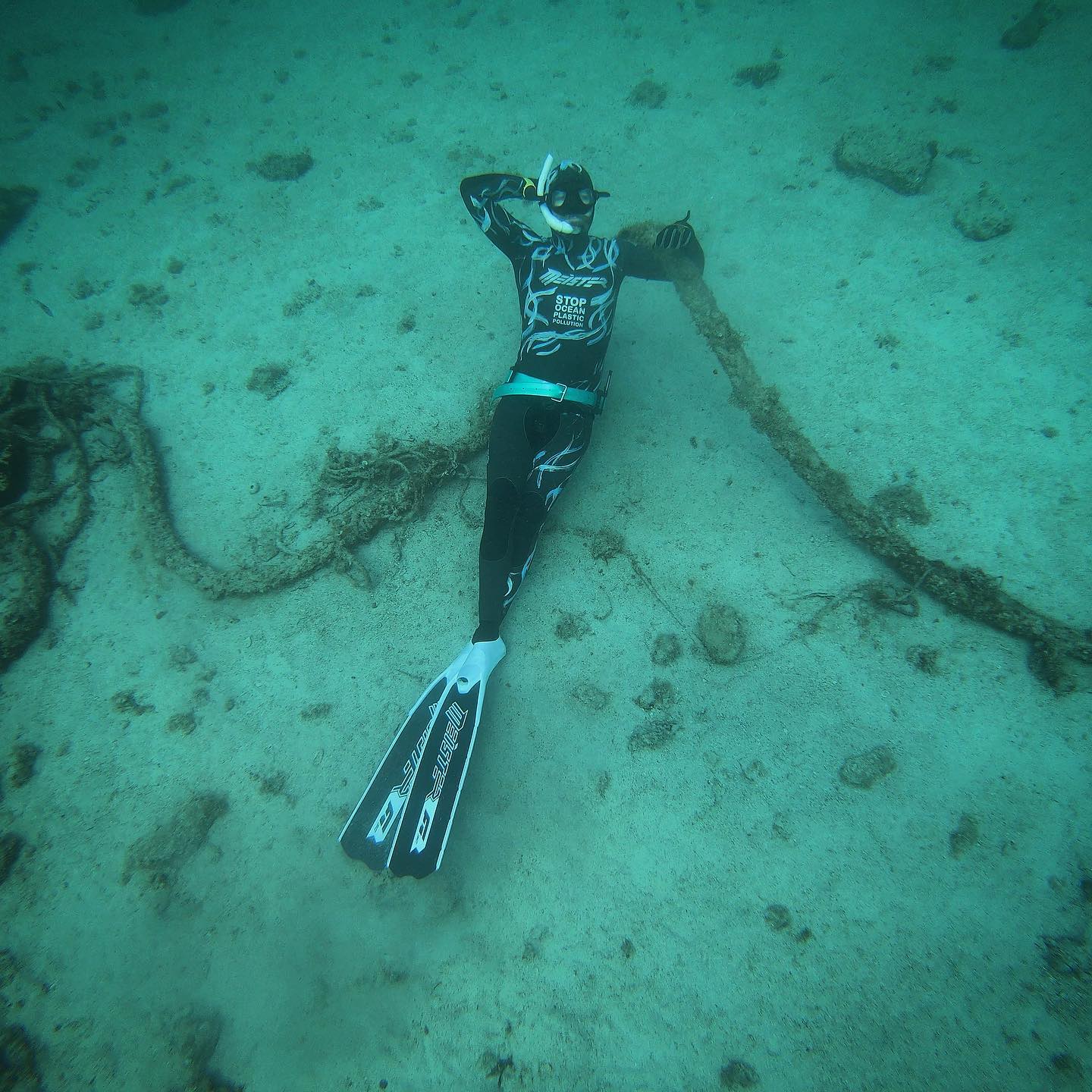 freediver meister lying down on sea bottom