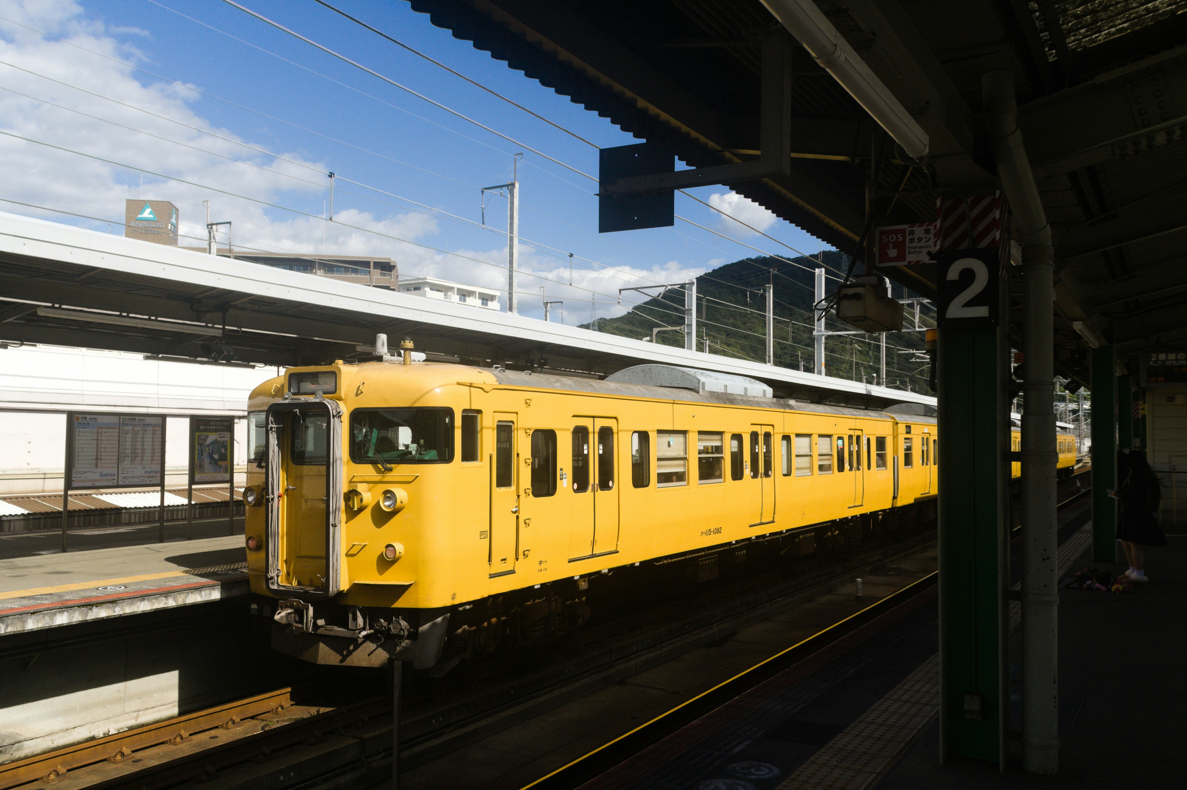 A bright yellow train at a station platform.