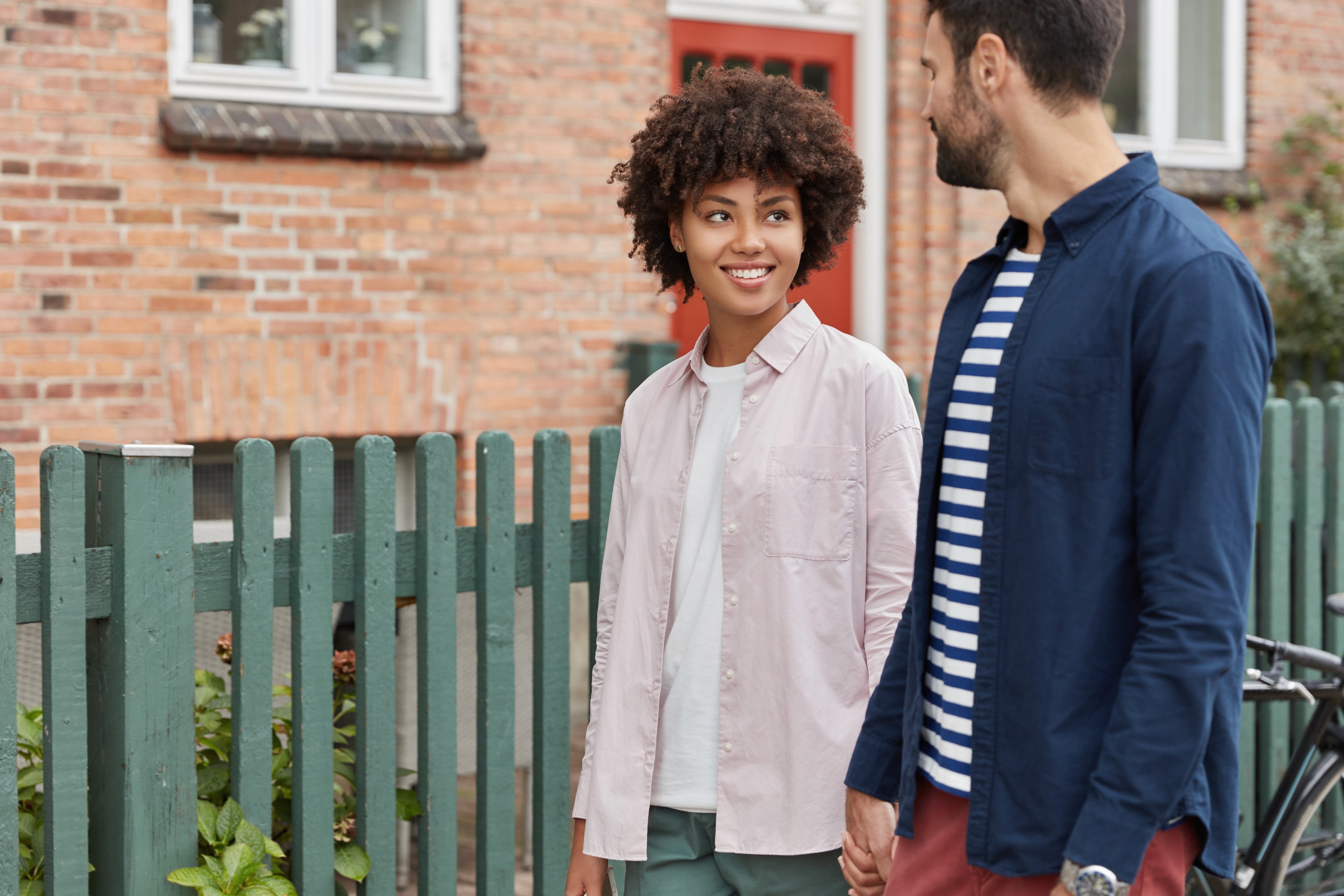 A smiling couple outside their home