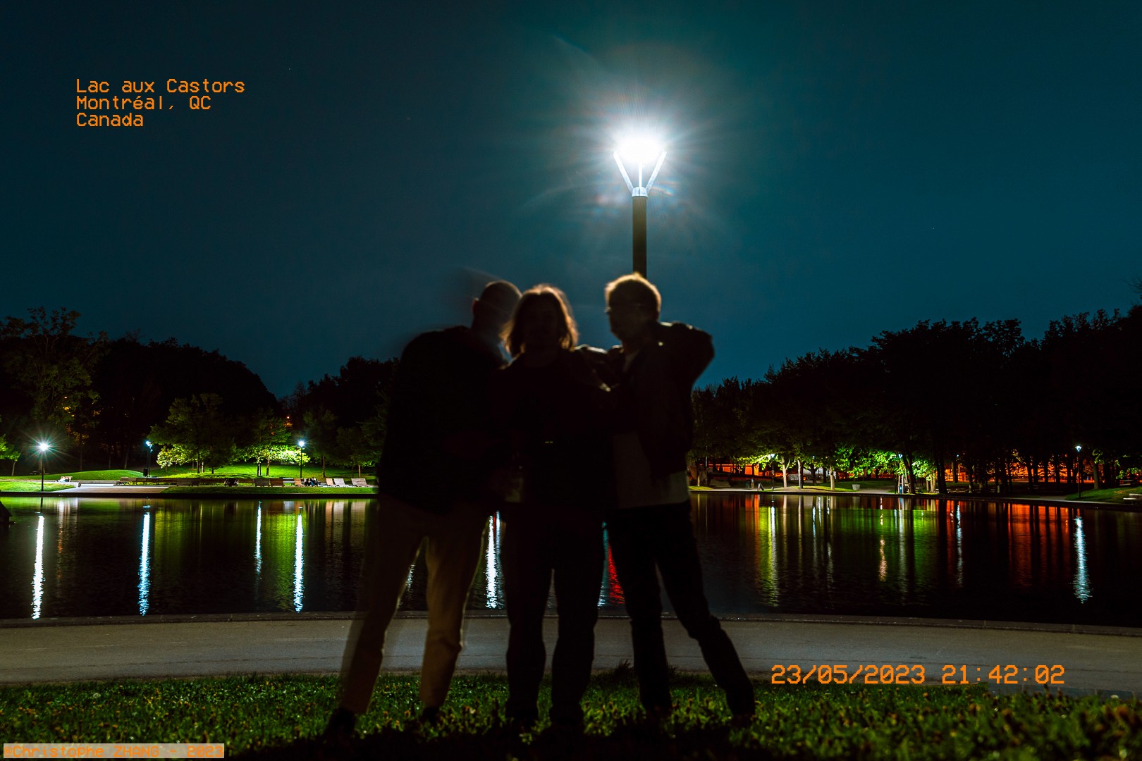 Scène nocturne au lac aux Castors, avec des amis posant près de l'eau sous un ciel étoilé.