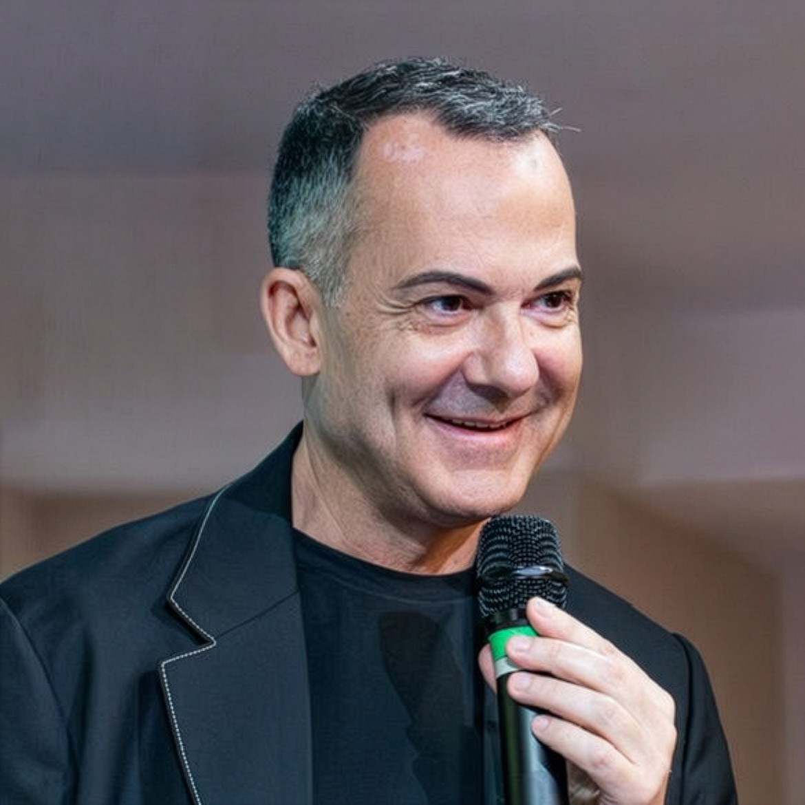 Portrait of a person in dark clothing speaking on a phone