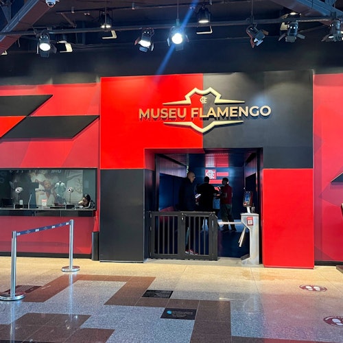 进入弗拉门戈博物馆，馆内装饰以红色和黑色为主，左侧设有一个有人值守的售票亭，一个人正通过正门进入。