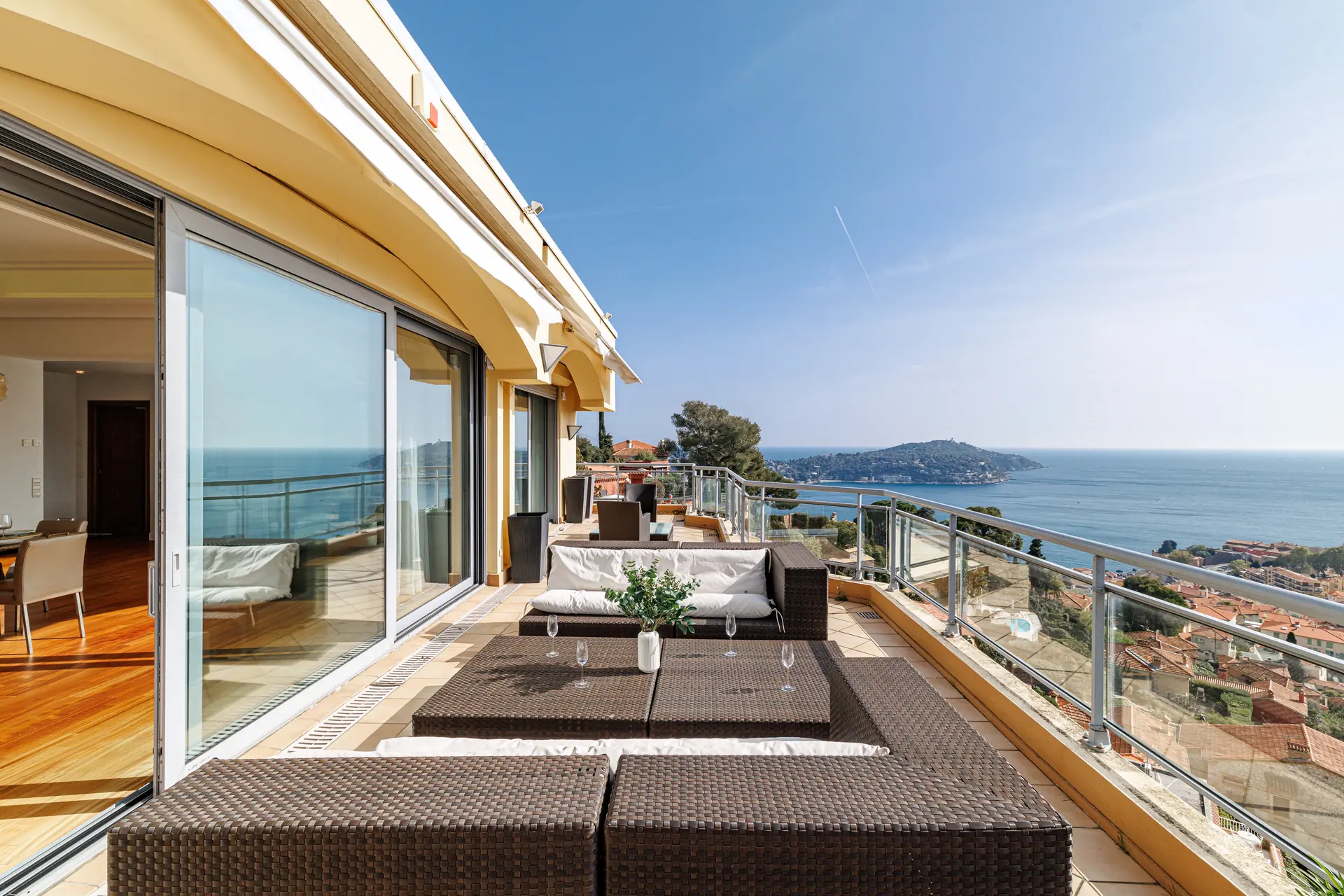 Photographie d'un balcon ensoleillé avec vue sur la Côte d'Azur