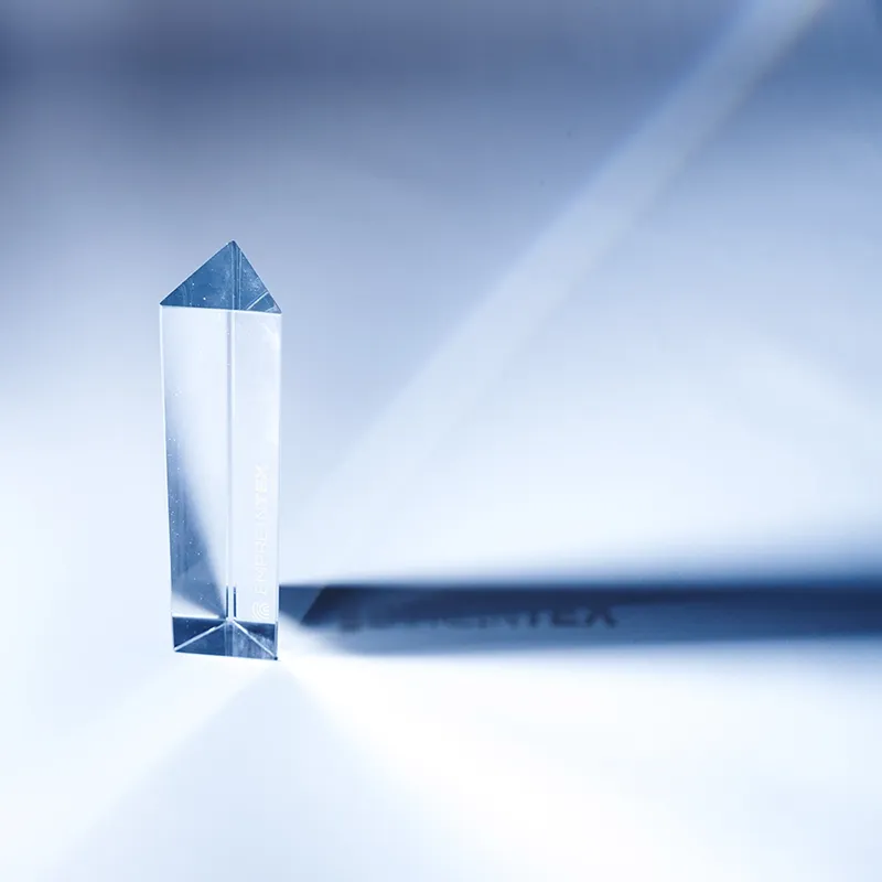 A smiling young man with crossed arms, wearing a plaid shirt and white t-shirt, poses against a dark background.