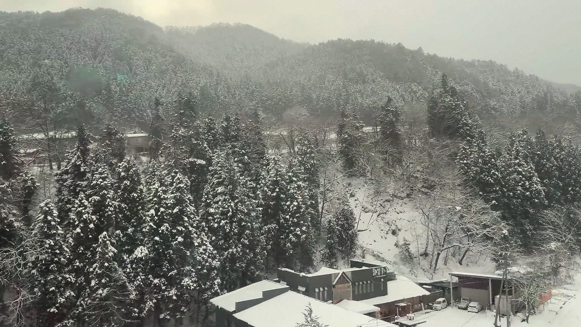 Snow-covered onsen village seen from above in the Nagano valley