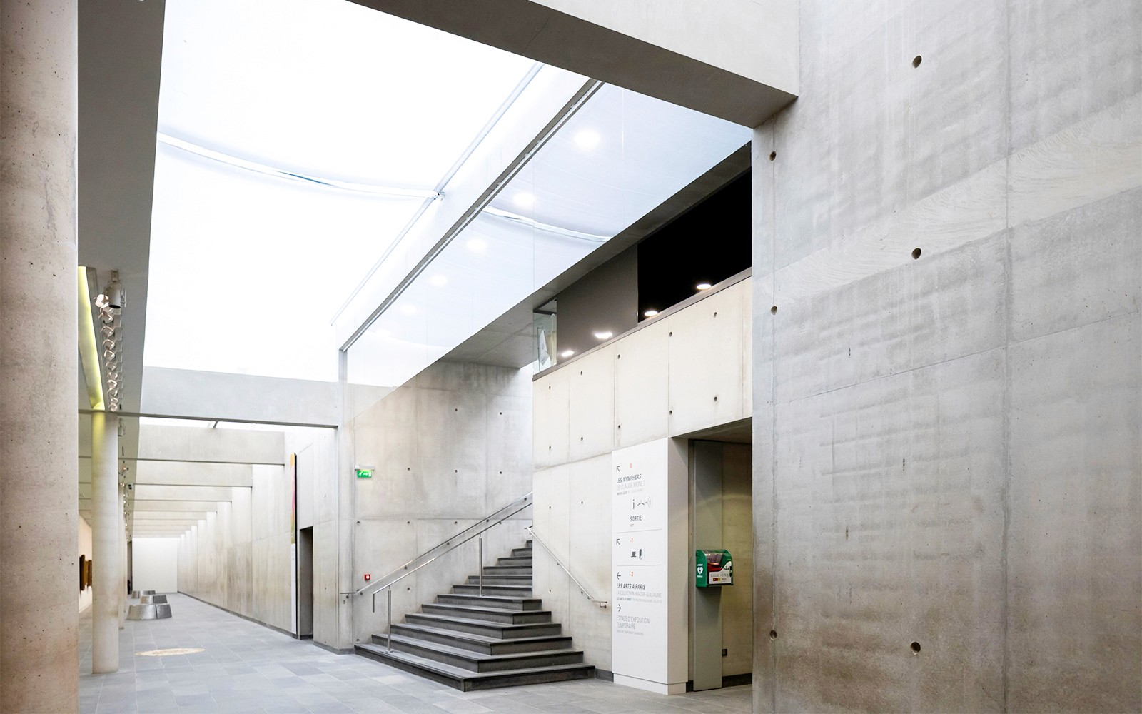Interior ng Orangerie Museum na may modernong kongkretong pader at hagdanan.