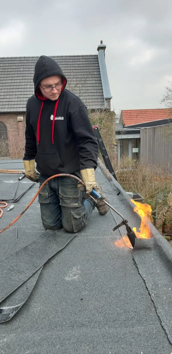 man in green and black plaid long sleeve shirt holding red and black cordless hand drill