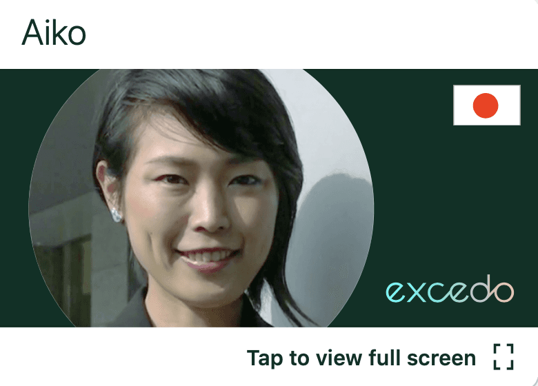 A headshot image of a Japanese businesswoman smiling and looking out