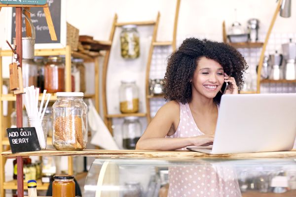 girl talking on phone in front of laptop