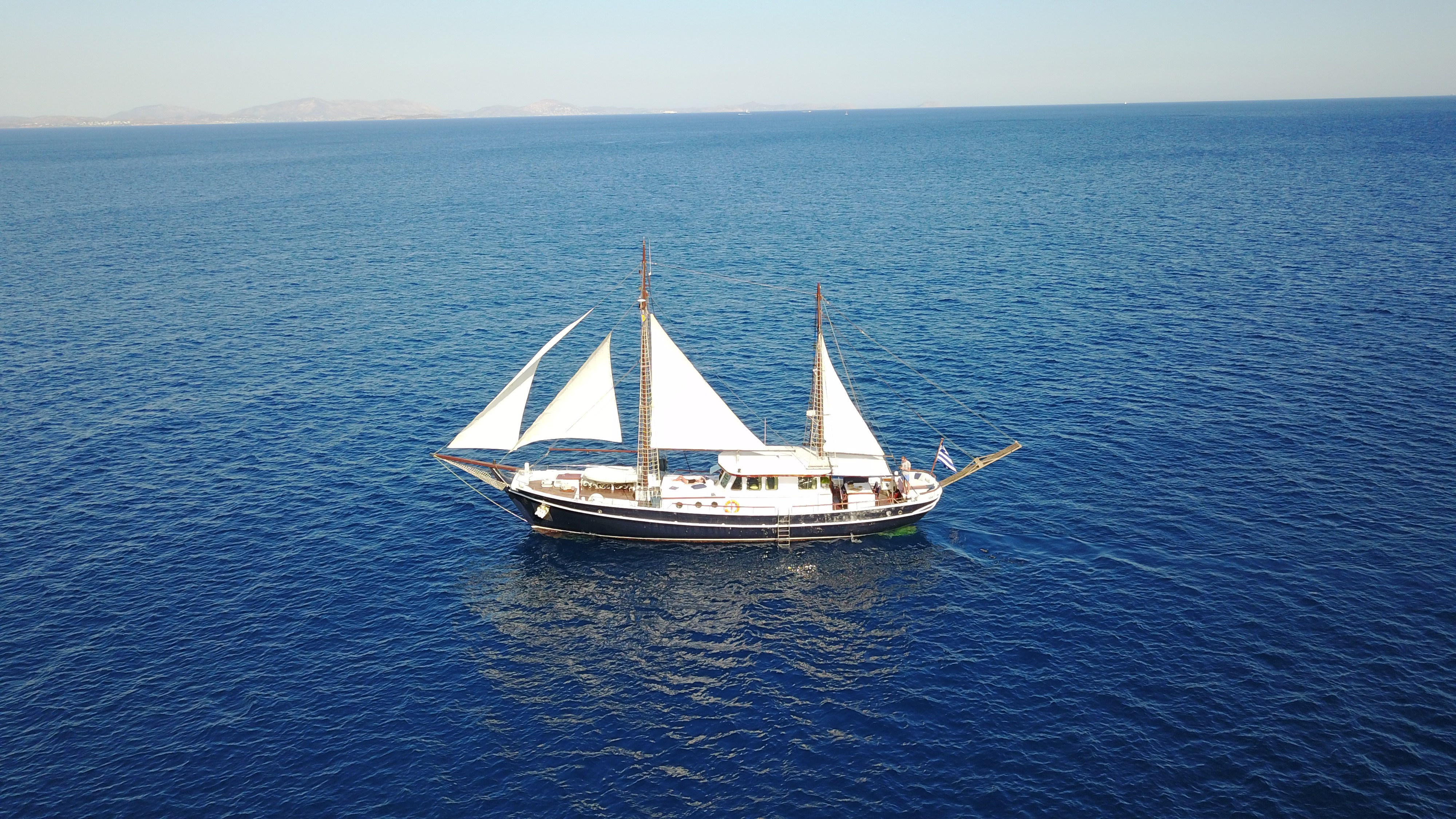 Desert road leading through golden plains toward rocky cliffs under a clear blue sky in AlUla.