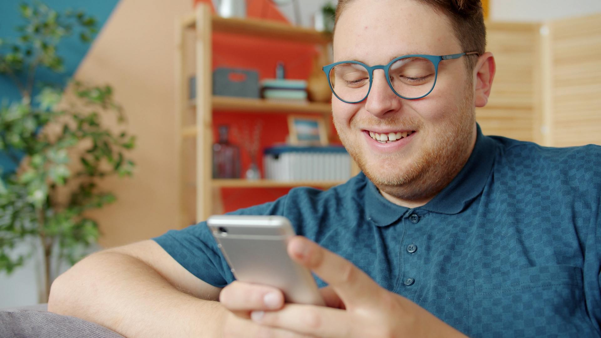 a person smiling and using his mobile phone