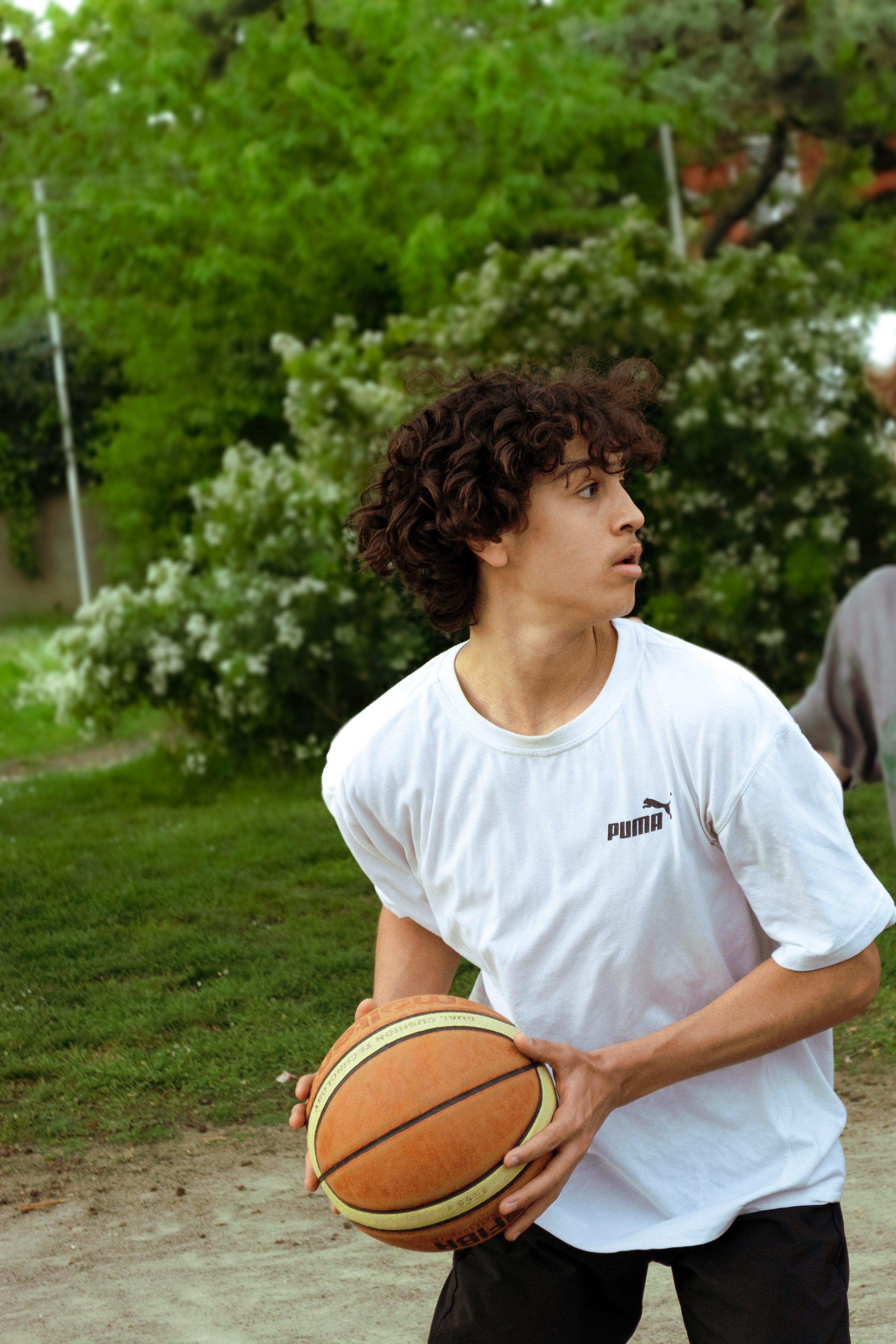 a young man holding a basketball on top of a basketball court
