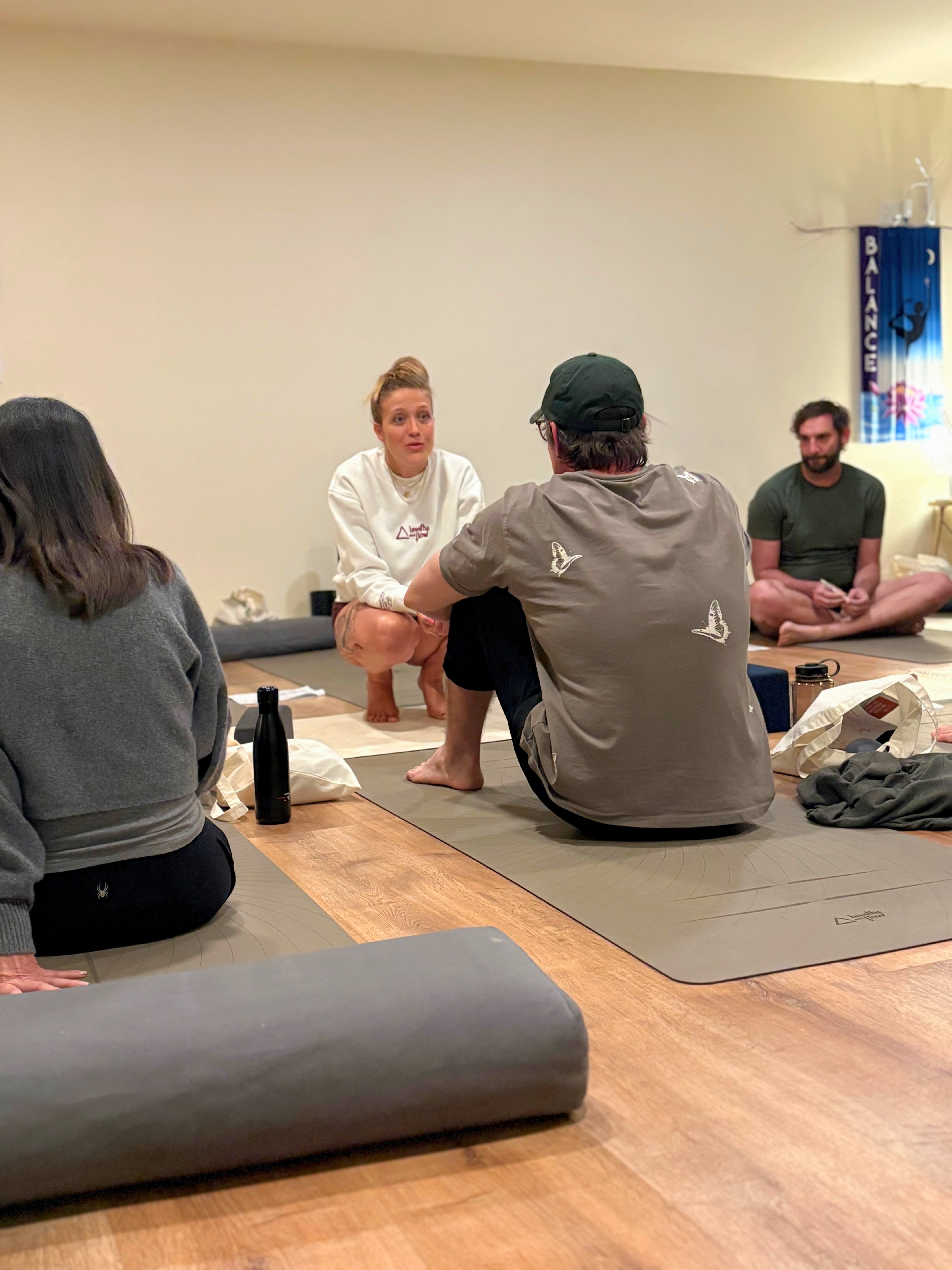 Group yoga retreat participants practicing together in a jungle studio.