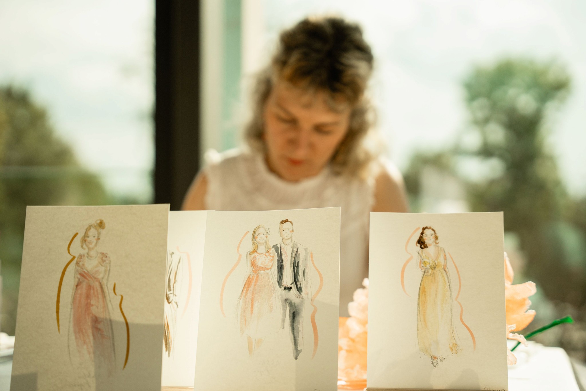 Nahaufnahme von handgezeichneten Modeillustrationen auf einer Hochzeitsfeier – eine kreative Idee für individuelle Gastgeschenke.